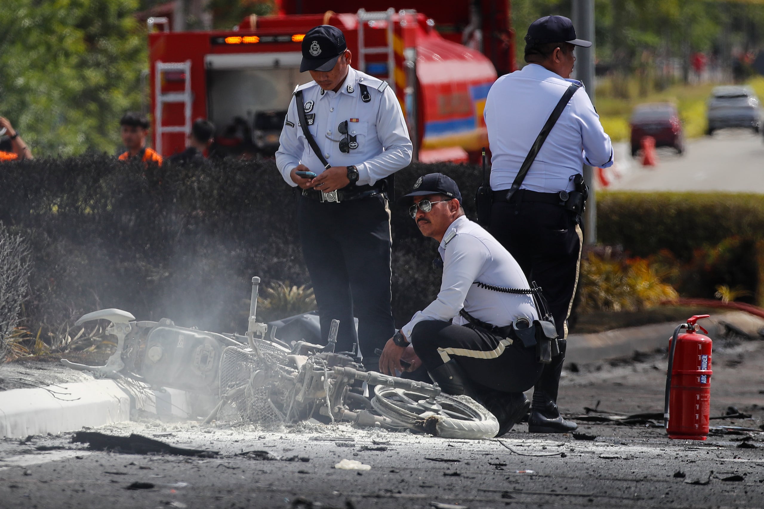Oficiales del Departamento de Bomberos y Rescate de Malasia inspeccionan la escena del accidente de una avioneta en Elmina, estado de Selangor, Malasia. (EFE/EPA/FAZRY ISMAIL)