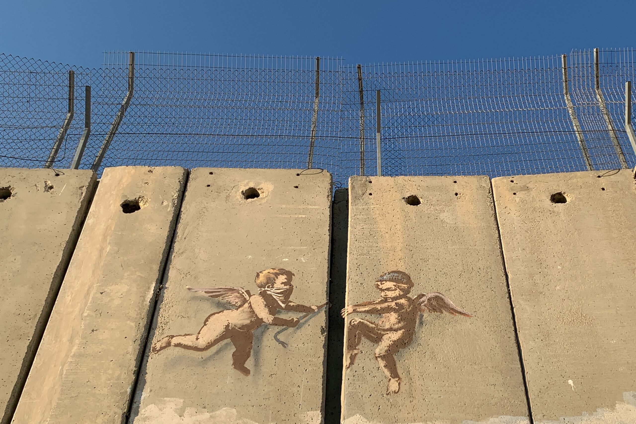 Vista de una obra del artista británico Banksy sobre el muro que divide Israel de Cisjordania en Belén. EFE/ Yemeli Ortega