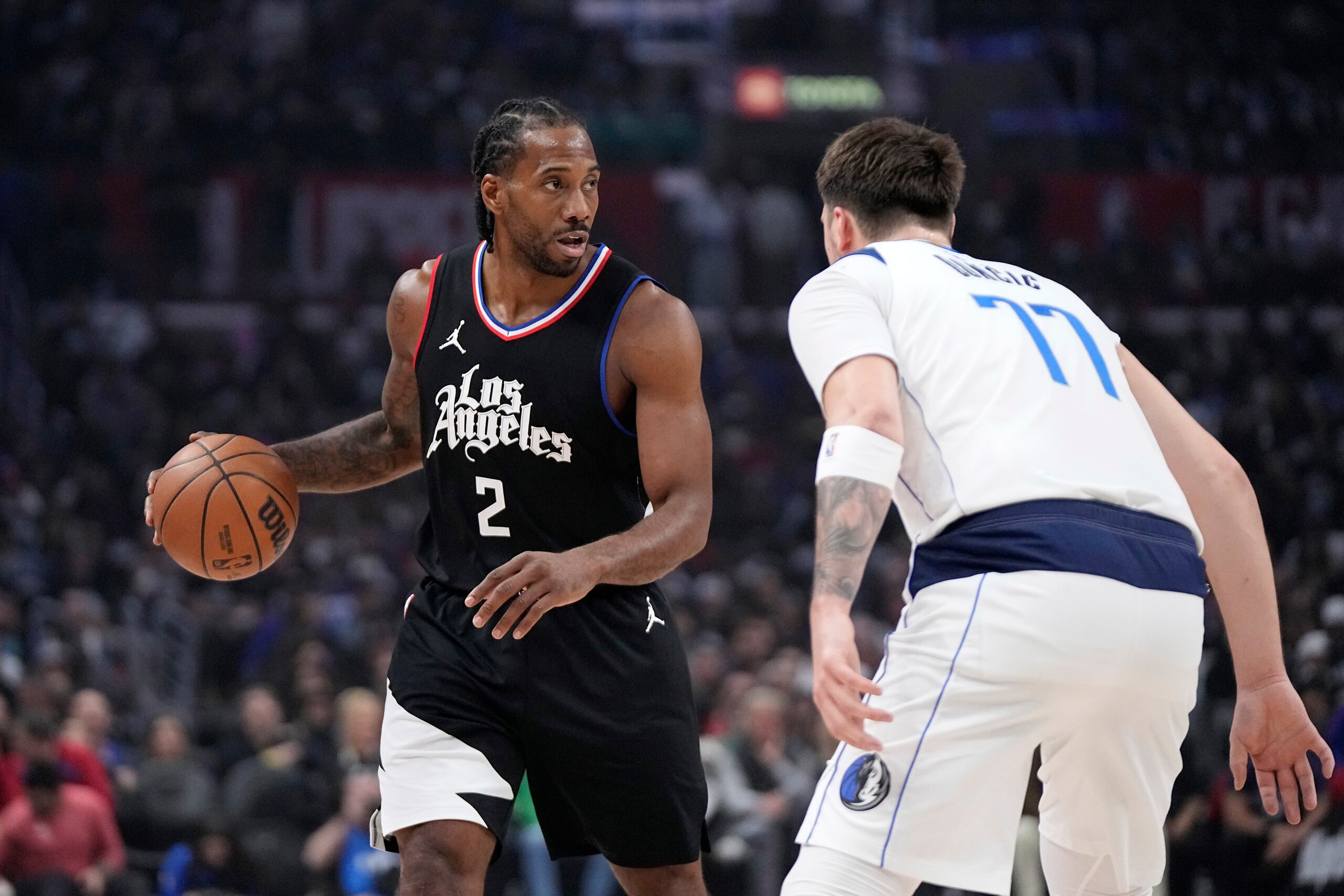 Kawhi Leonard, de los Clippers de Los Ángeles, busca pasar el balón ante la defensa de Luka Doncic, de los Mavericks de Dallas.