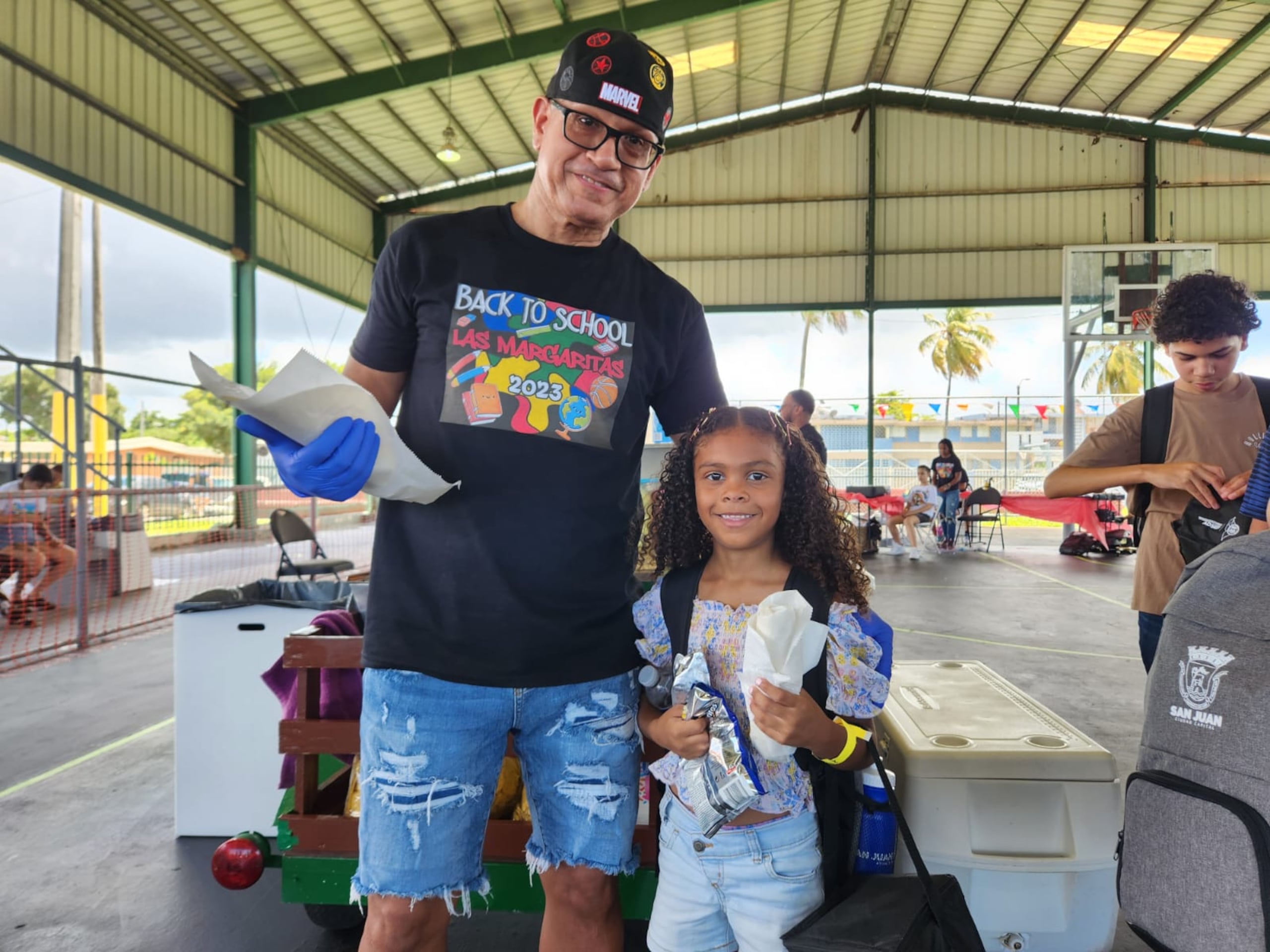 El líder comunitario Julio Álvarez Ayuso y la niña Jeirylee Santiago Dávila.