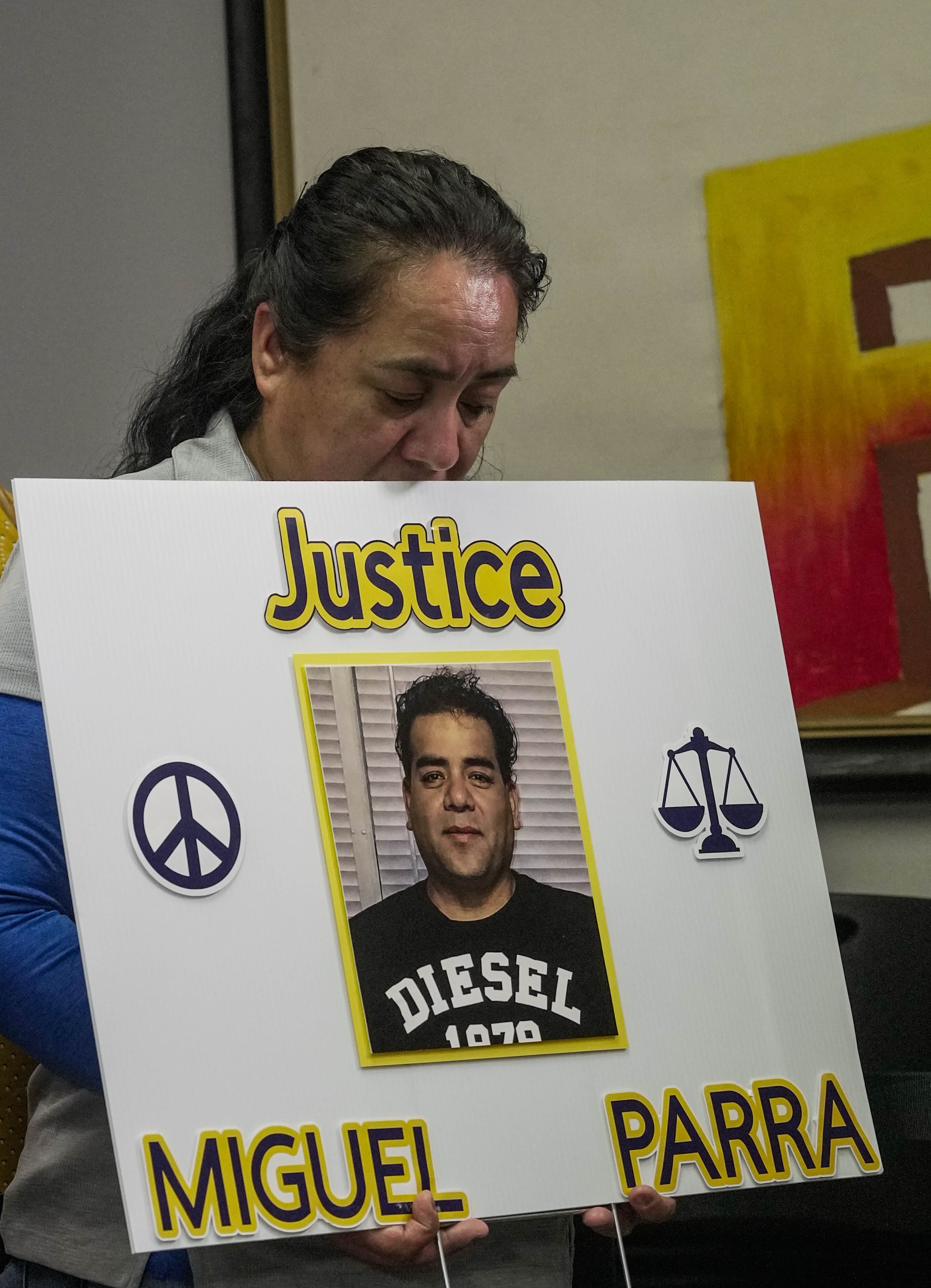 Carmen, hermana de Miguel Parra Hernández, sostiene un cartel en una conferencia de prensa sobre la acción del Servicio de Inmigración y Control de Aduanas.