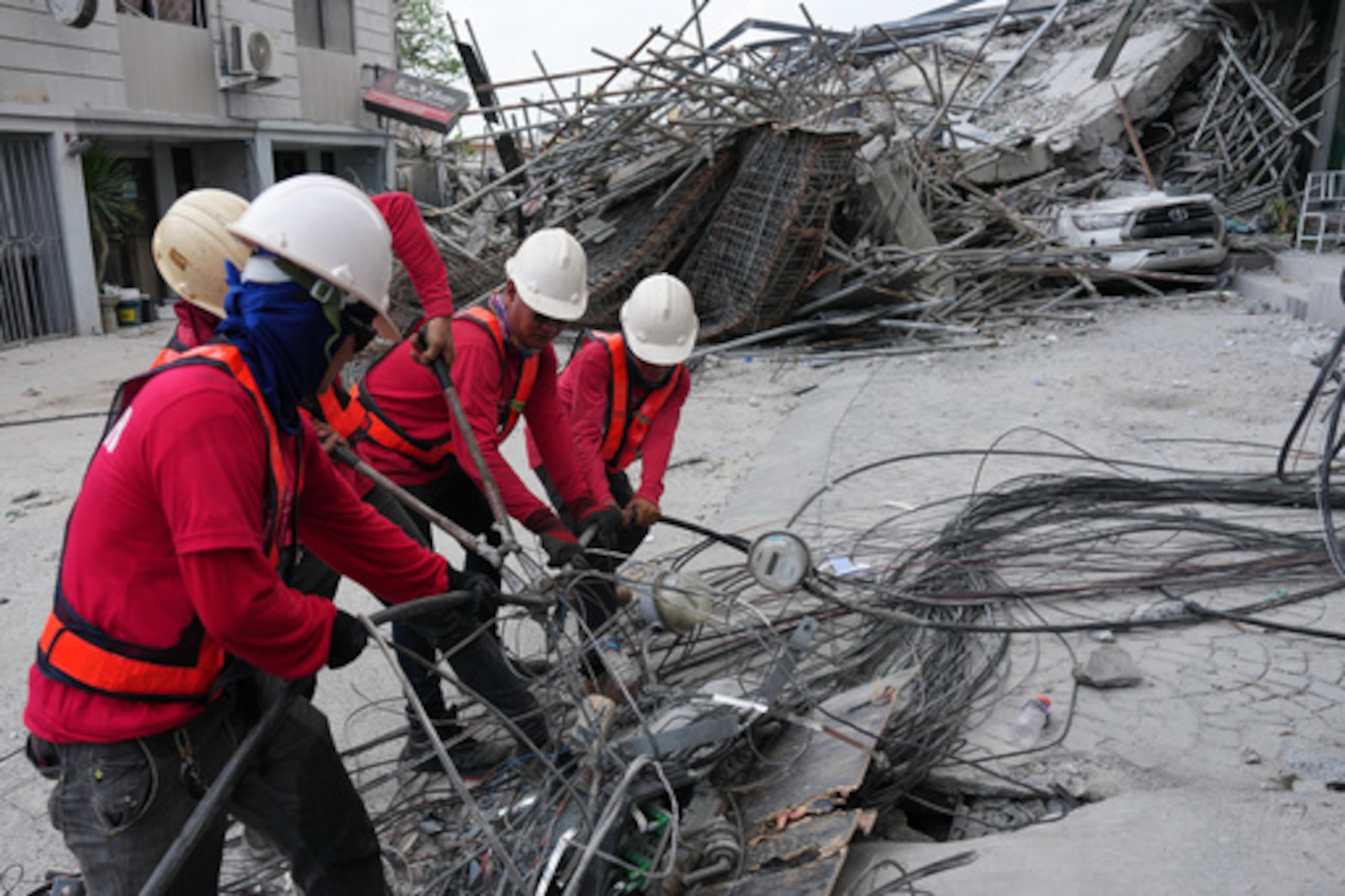 Trabajadores cortan cables durante una operación de búsqueda en un edificio derrumbado donde se cree que hay varias personas atrapadas en la ciudad de Angeles, en la provincia de Pampanga, al norte de Manila, Filipinas, el lunes 25 de mayo de 2026. (AP Photo/Aaron Favila)