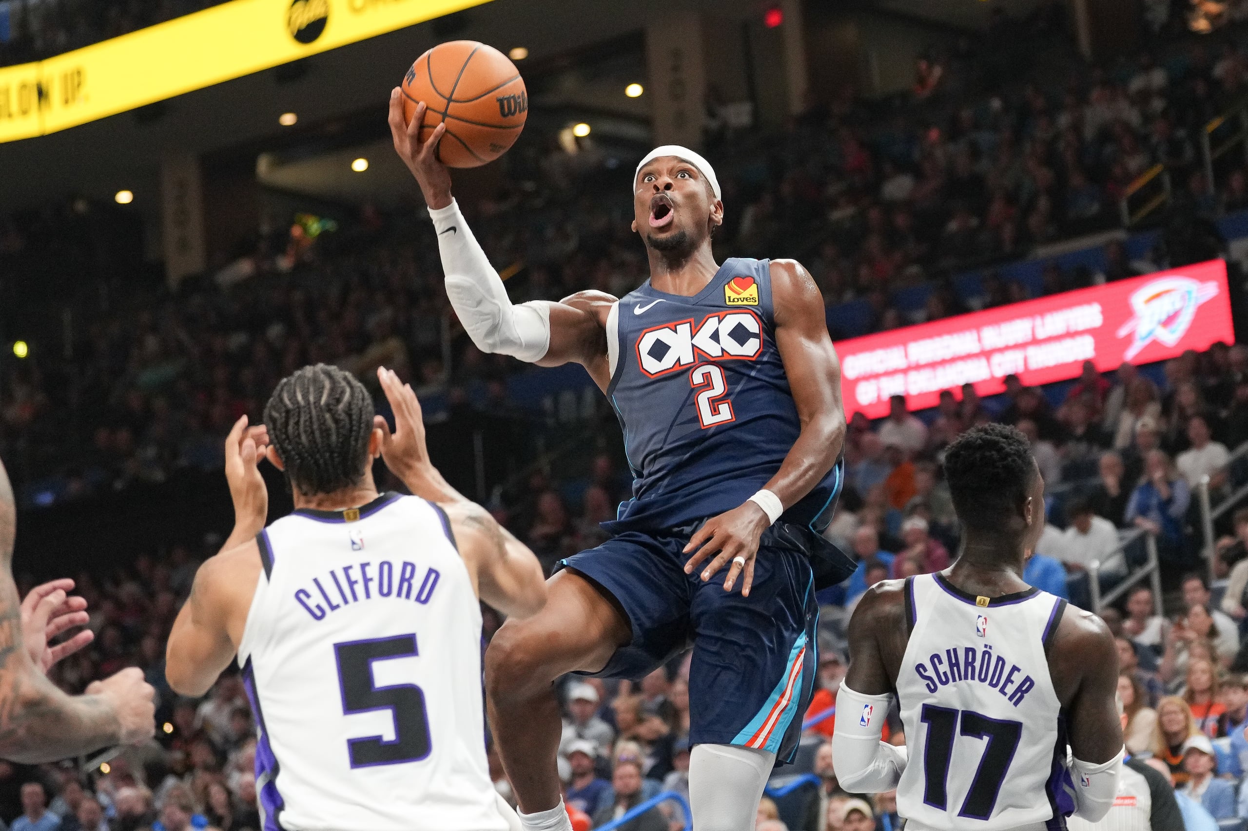 El base del Thunder de Oklahoma City Shai Gilgeous-Alexander lanza sobre Nique Clifford y Dennis Schröder de losKings de Sacramento el miércoles 19 de noviembre del 2025.
