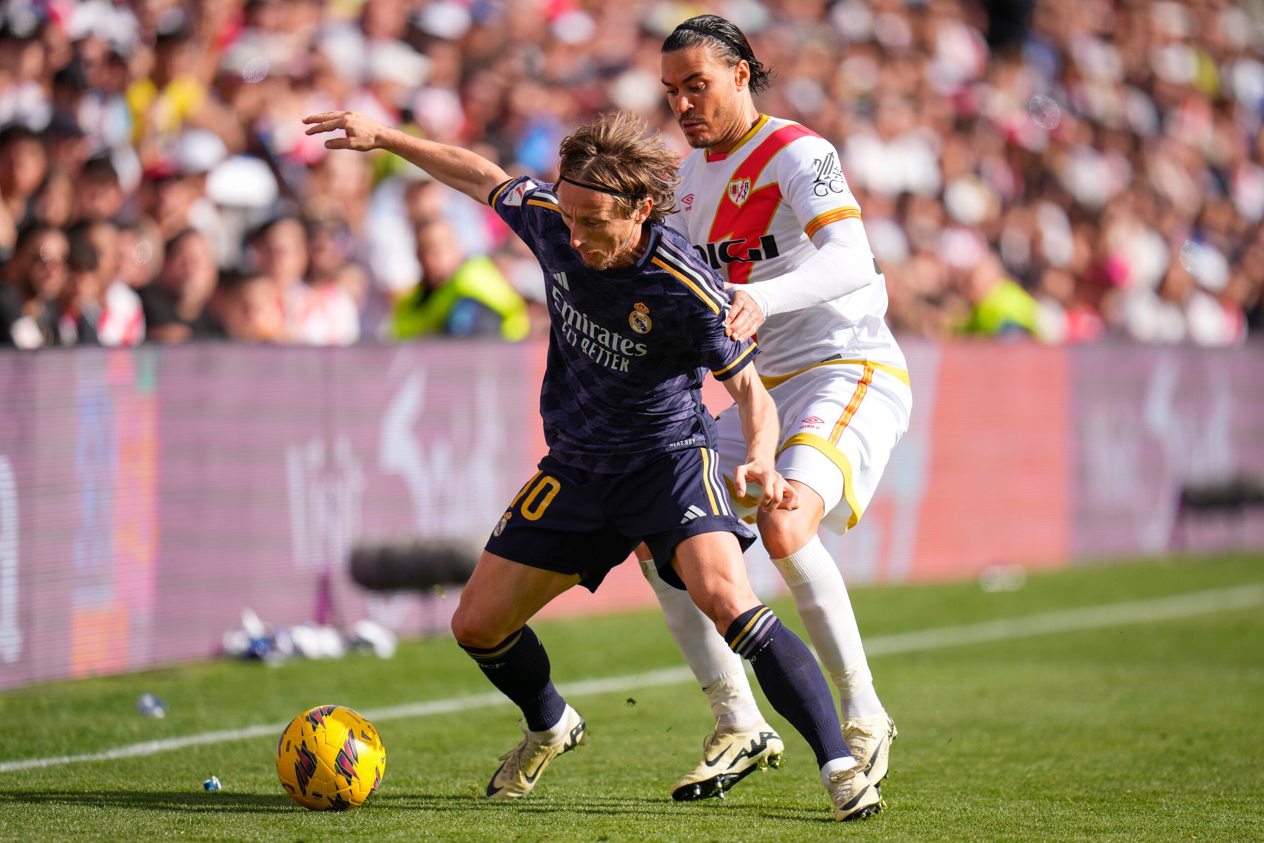 Luka Modric (izquierda) pugna por el balón con Raúl de Tomás del Rayo Vallecano en la Liga española, el domingo 18 de febrero de 2024, en Madrid. (AP Foto/Manu Fernández)