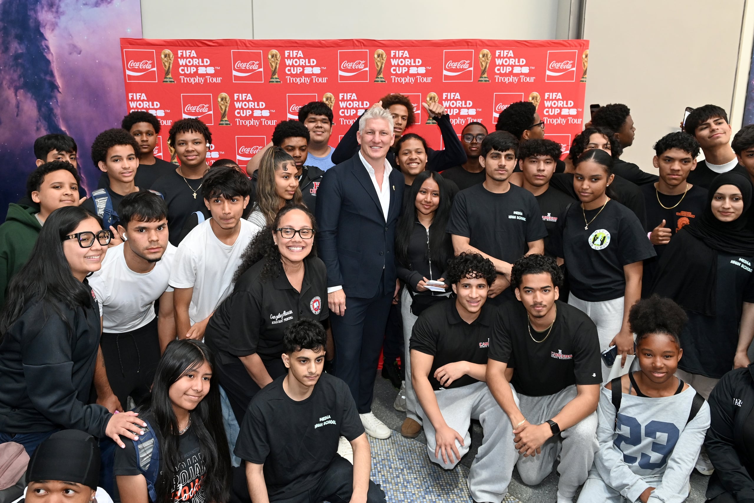 El exjugador de fútbol de Alemania Bastian Schweinsteiger (c) posa con estudiantes durante el Tour del Trofeo de la Copa Mundial de la FIFA organizado por Coca-Cola en el Museo Americano de Historia Natural el 2 de junio en Nueva York (EFE/The Coca Cola Company)