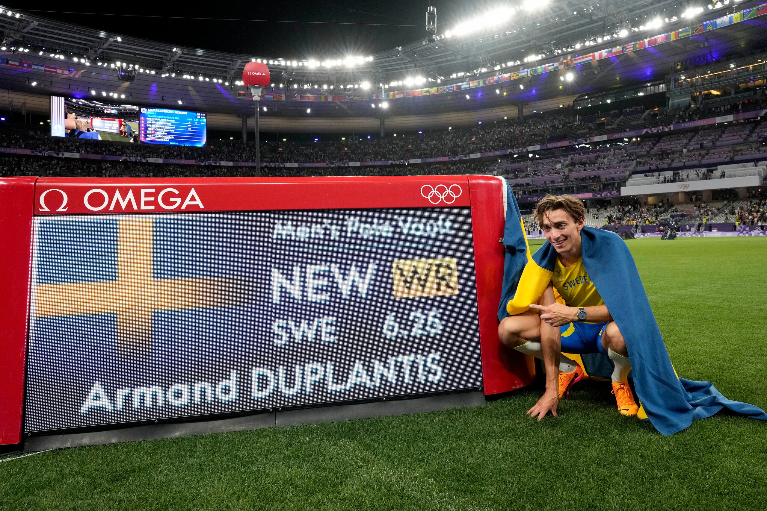 Armand Duplantis posa frente a una pizarra que da fe de su nuevo récord.