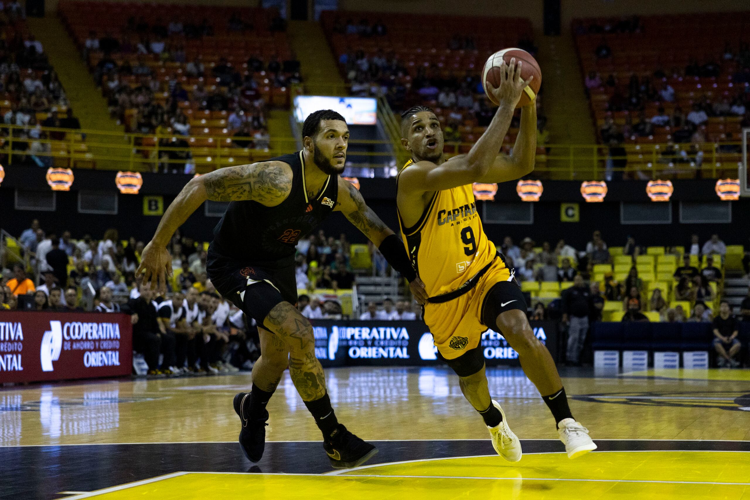 Alfonso Plummer, de los Capitanes de Arecibo, busca atacar el canasto frente a Emmy Andujar, de los Cangrejeros de Santurce.