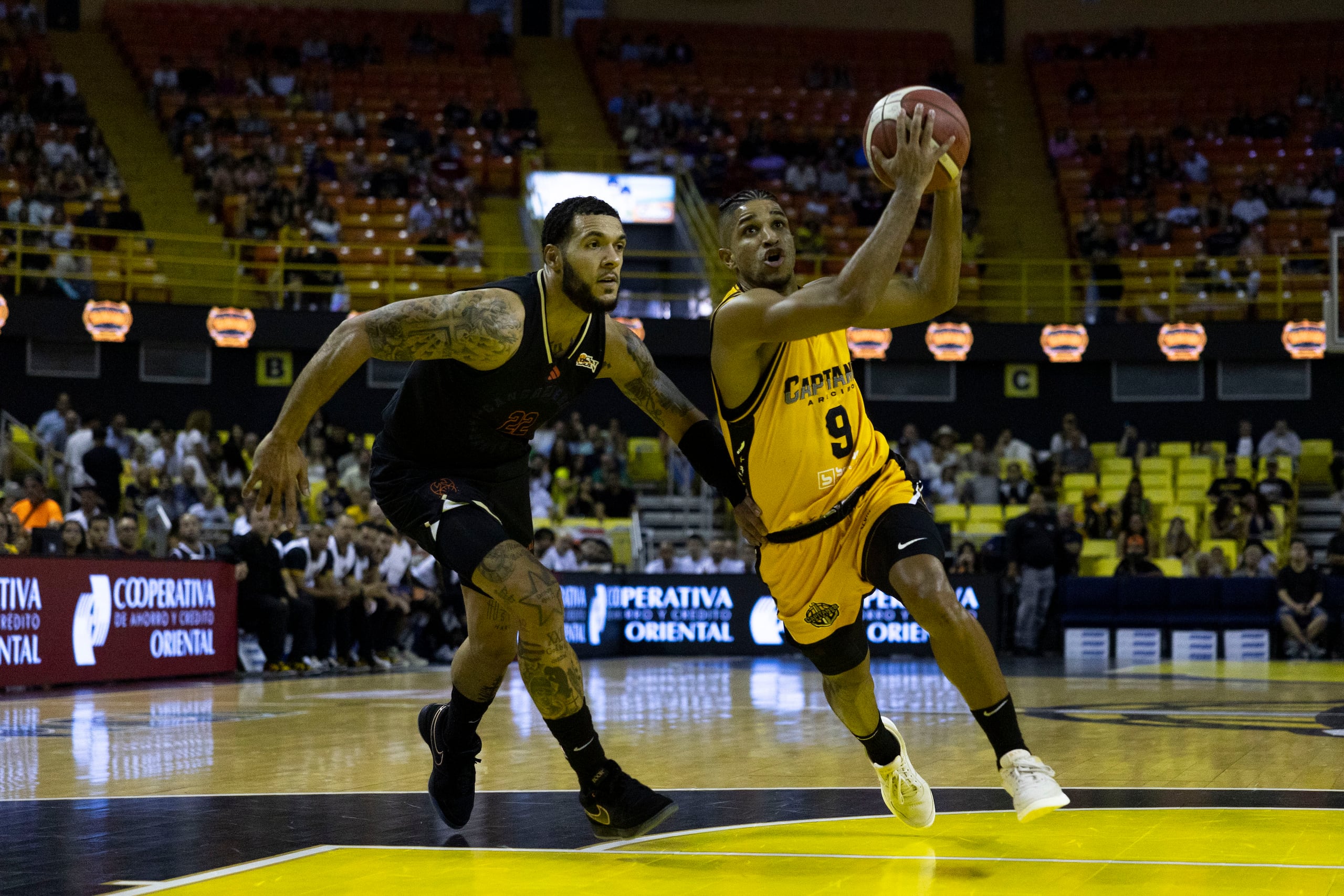 Alfonso Plummer, de los Capitanes de Arecibo, busca atacar el canasto ante la defensa de Emmy Andujar, de los Cangrejeros de Santurce.