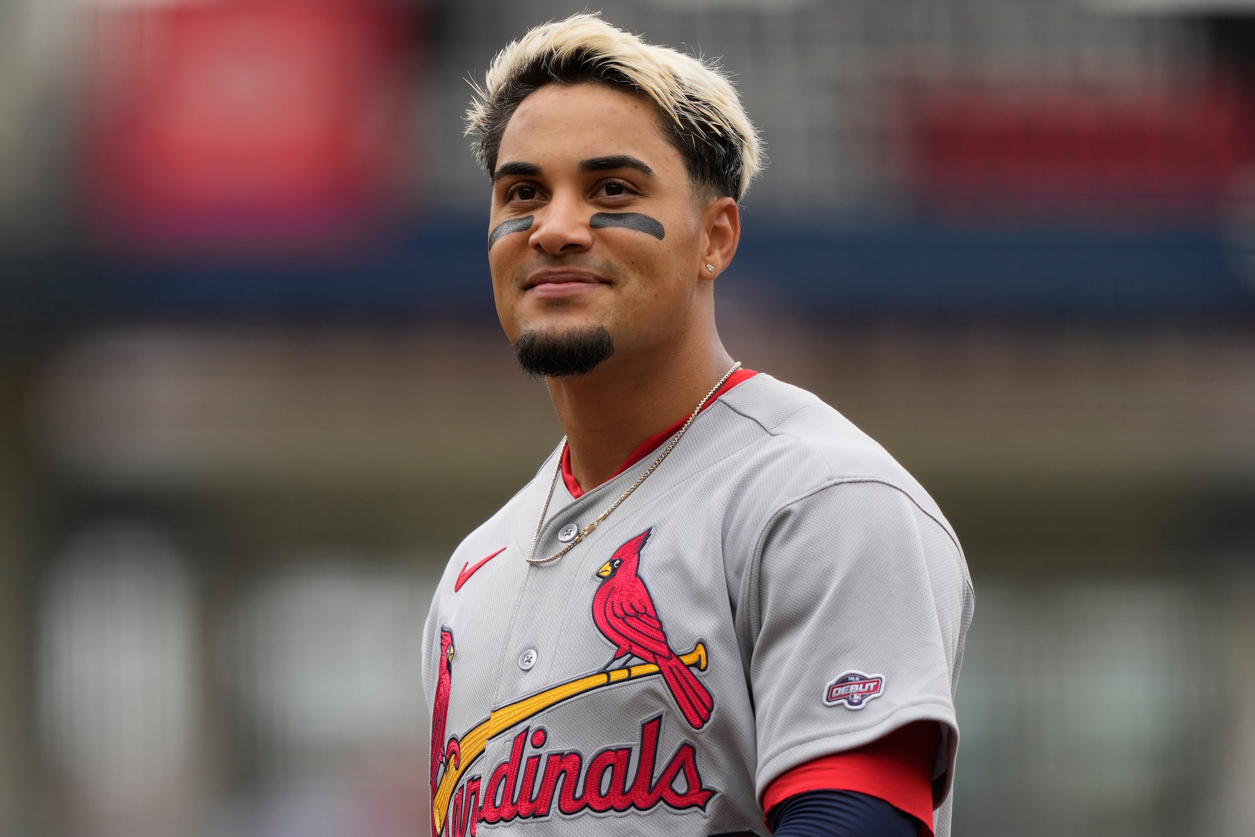 Bryan Torres, vistiendo una camisa con un parcho que le identifica como un jugador realizando su debut en las Mayores, sonríe durante un momento de su glorioso primer juego con los Cardinals.