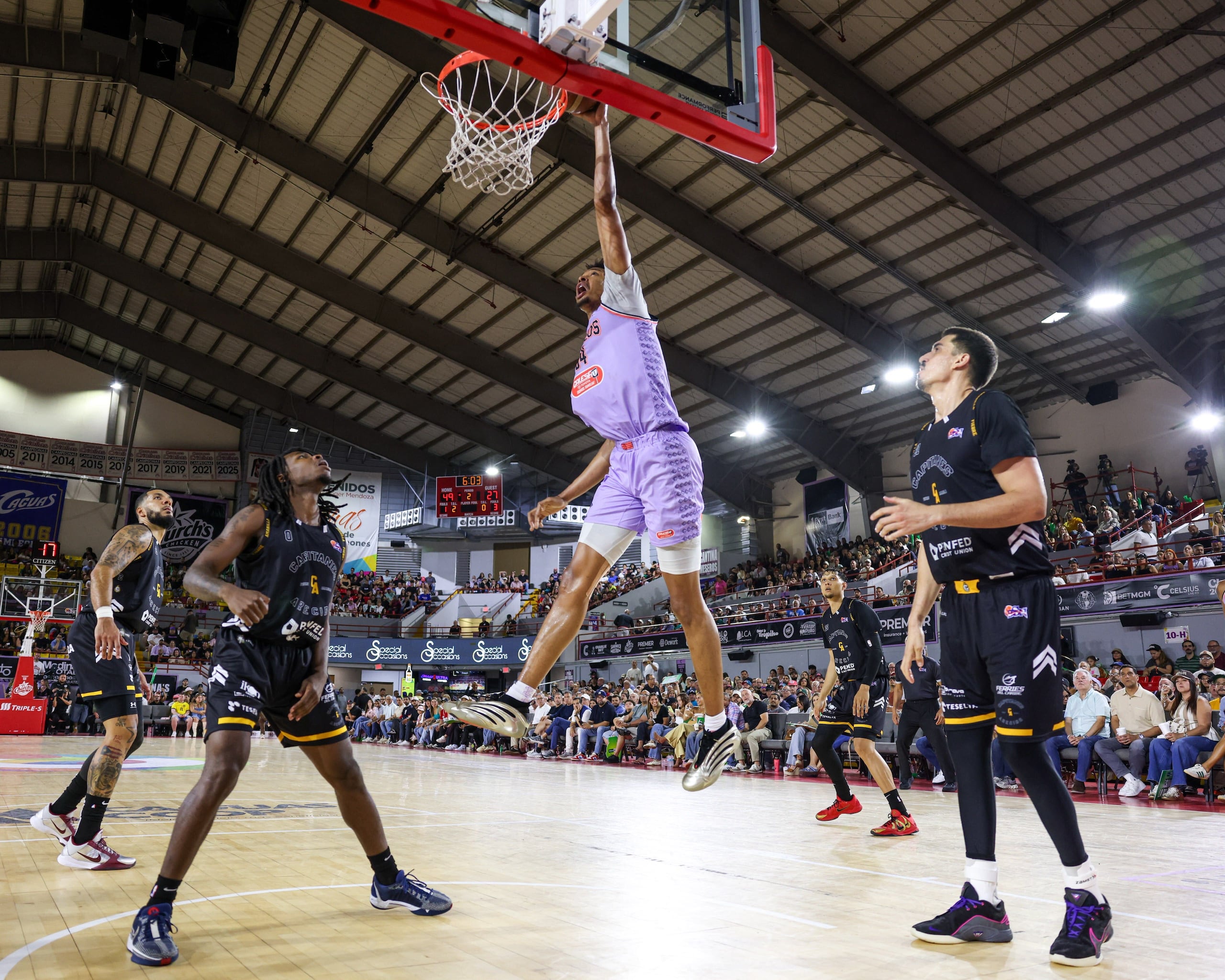 Moses Brown, de los Criollos de Caguas, donquea el balón ante las miradas de los jugadores de los Capitanes de Arecibo.