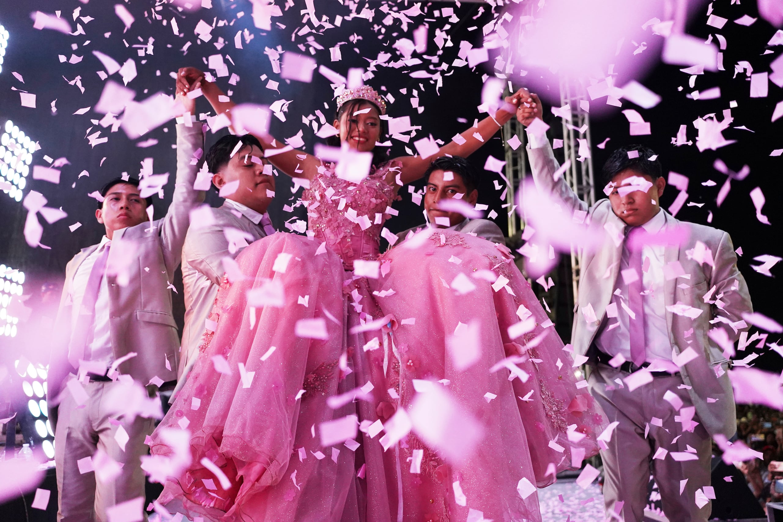 Confetti falls over Isela Santiago Morales during her 15th birthday party at a stadium in Axtla de Terrazas, Mexico, Saturday, Aug. 23, 2025, organized by the community after her father's social media appeal drew support following her first sparsely attended celebration. (AP Photo/Mauricio Palos)