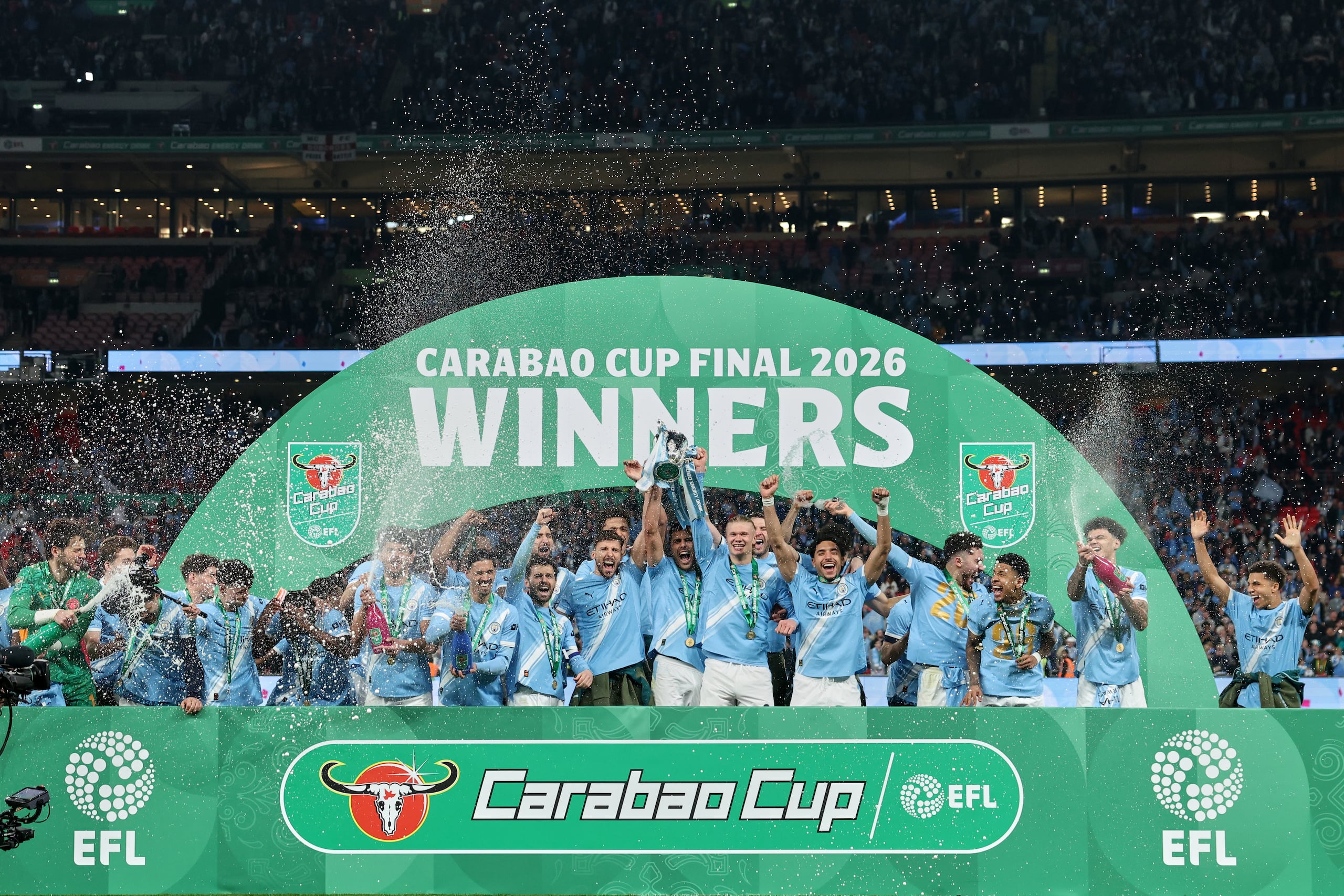 Jugadores del Manchester City celebran con el trofeo tras ganar la Copa de la Liga inglesa al superar en la final al Arsenal el domingo 22 de marzo del 2026. (AP Foto/Richard Pelham)