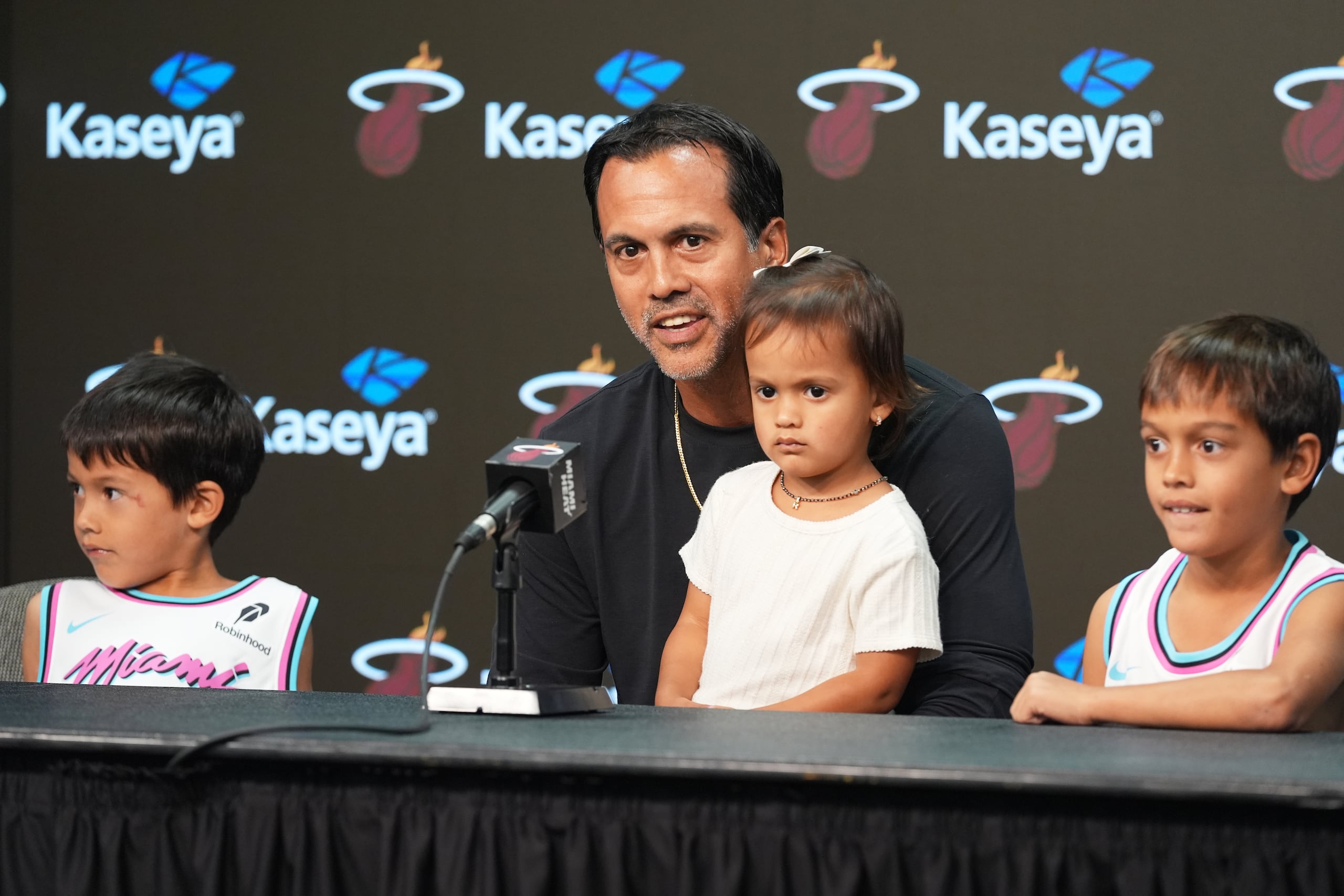 Erik Spoelstra, head coach del Heat de Miami, acompañado por sus hijos, comenta en conferencia de prensa sobre el incendio que destruyó su casa, previo al partido de la Copa NBA contra los Hornets de Charlotte, el viernes 7 de noviembre de 2025, en Miami. (AP Foto/Marta Lavandier)
