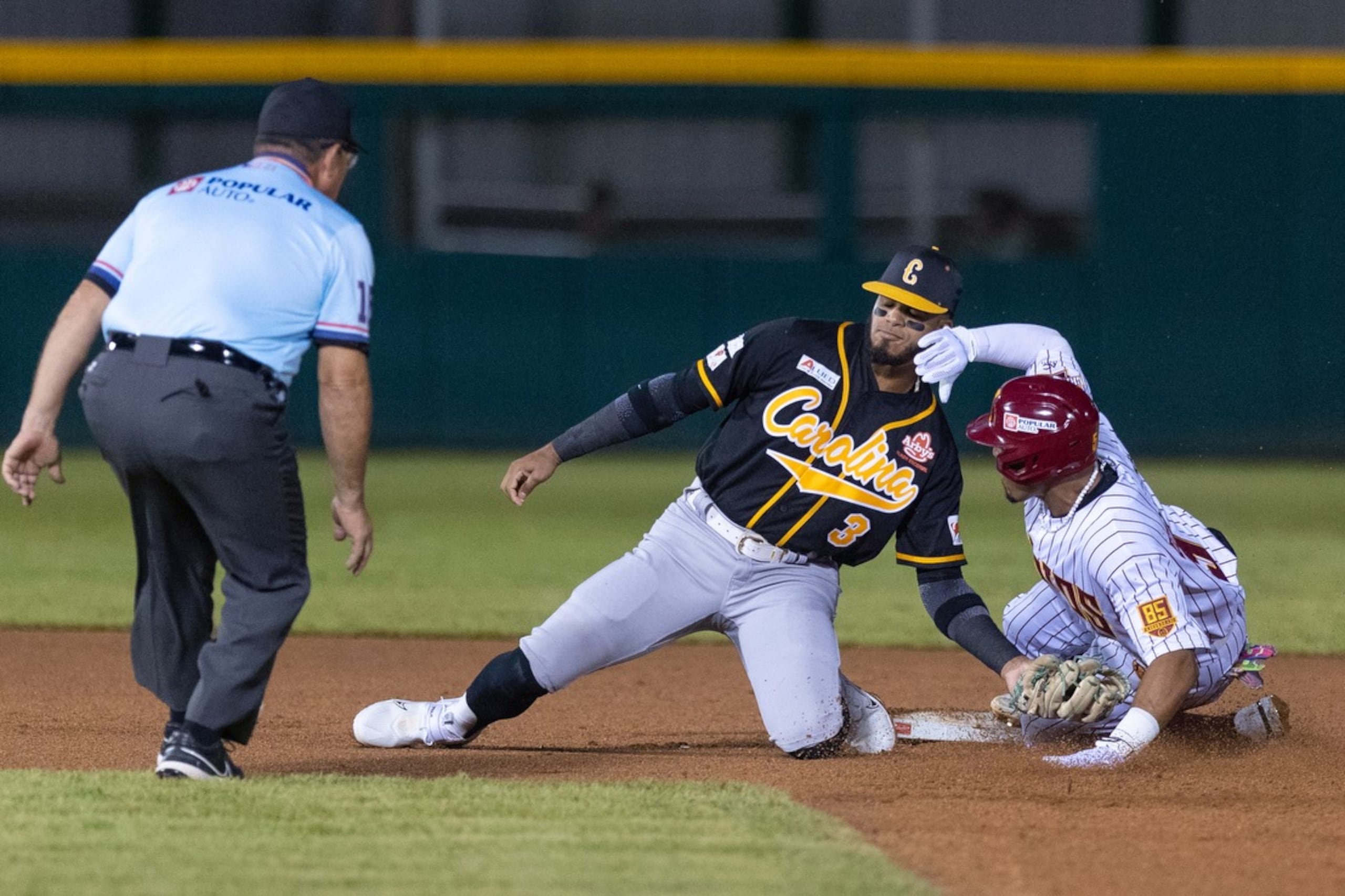 El campocorto de los Gigantes de Carolina, Delvin Pérez, realiza una jugada de out en segunda base contra los Indios de Mayagüez durante el partido inaugural de la temporada 2023-24 del béisbol invernal.