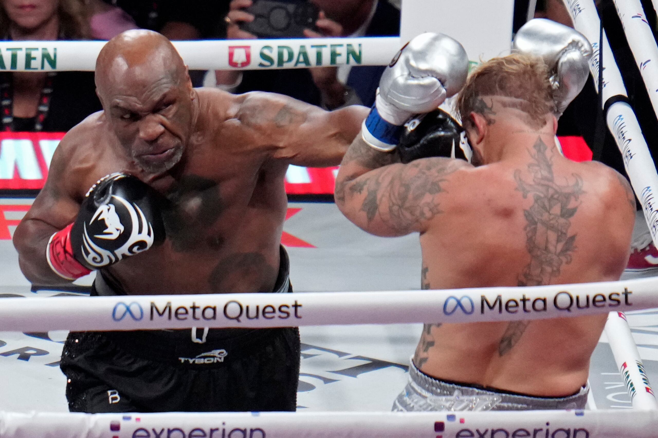 Mike Tyson lanza una zurda al rostro de Jake Paul durante su pelea de exhibición.