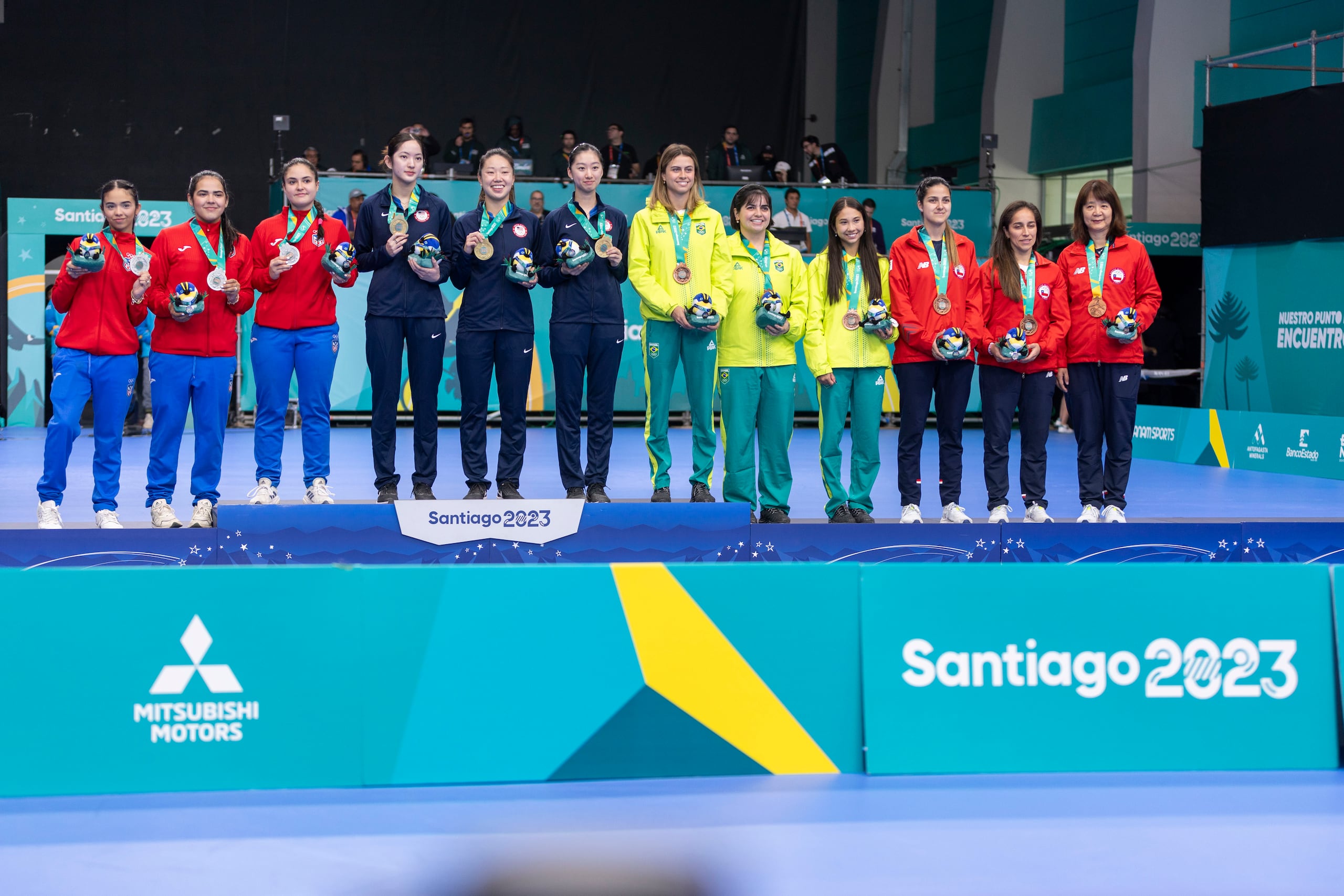Los equipos medallistas del torneo por equipo de los Juegos Panamericanos Santiago 2023. De izquierda a derecha: Melanie Díaz, Adriana Díaz y Brianna Burgos; la estadounidense Rachel Sung, Lily Zhang y Amy Wang, ganadoras del oro; y Bruna Takahashi, Bruna Costa y Giulia Takahashi, de Brasil; y Daniela Ortega, Paulina Vega y Zhiying Zeng de Chile, ganadoras de bronce