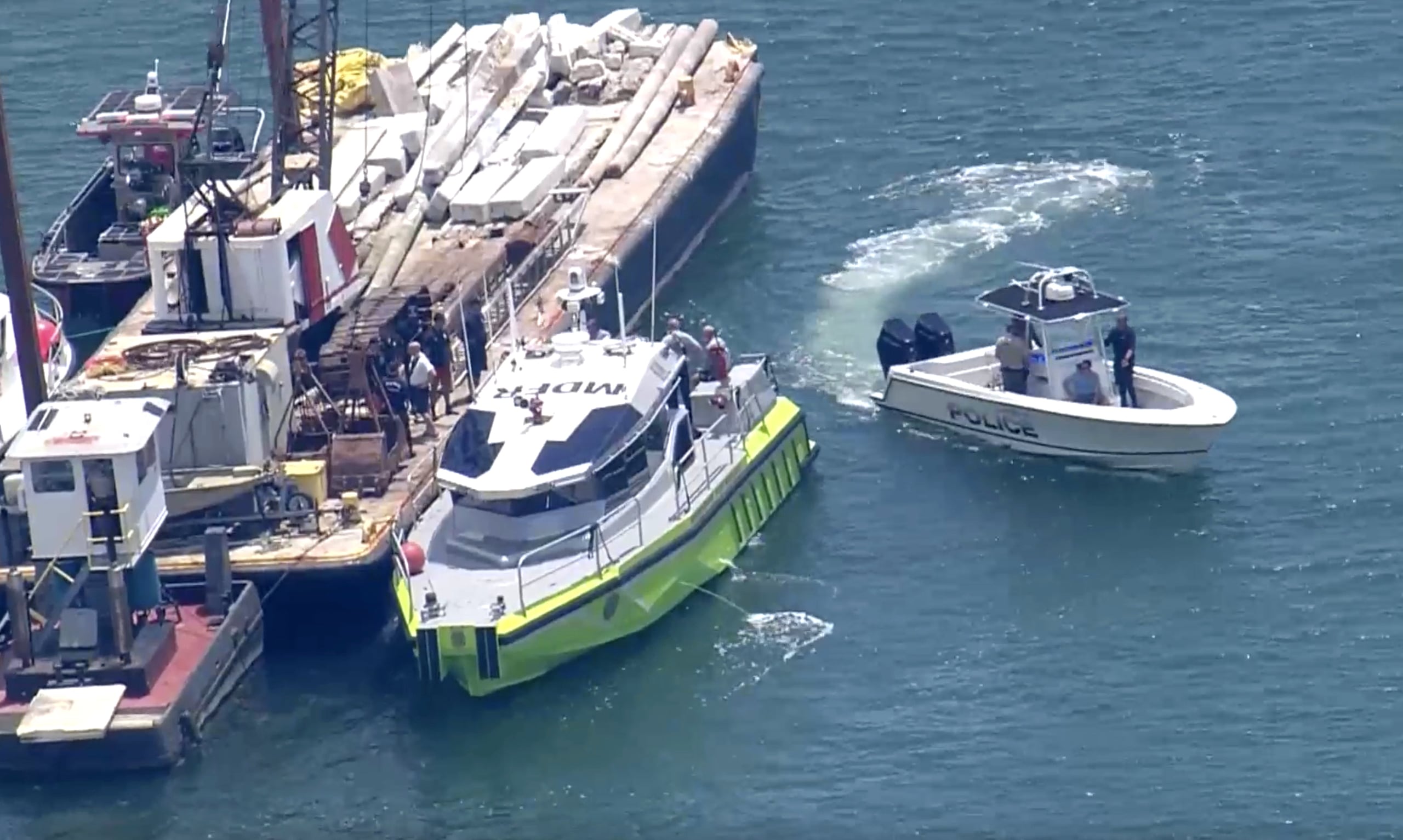 Esta imagen, tomada de un video proporcionado por WSVN-TV, muestra a personal de Rescate de Bomberos de Miami-Dade, la Guardia Costera, la Policía y otros en embarcaciones alrededor de la barcaza involucrada en el accidente, el lunes en Miami.