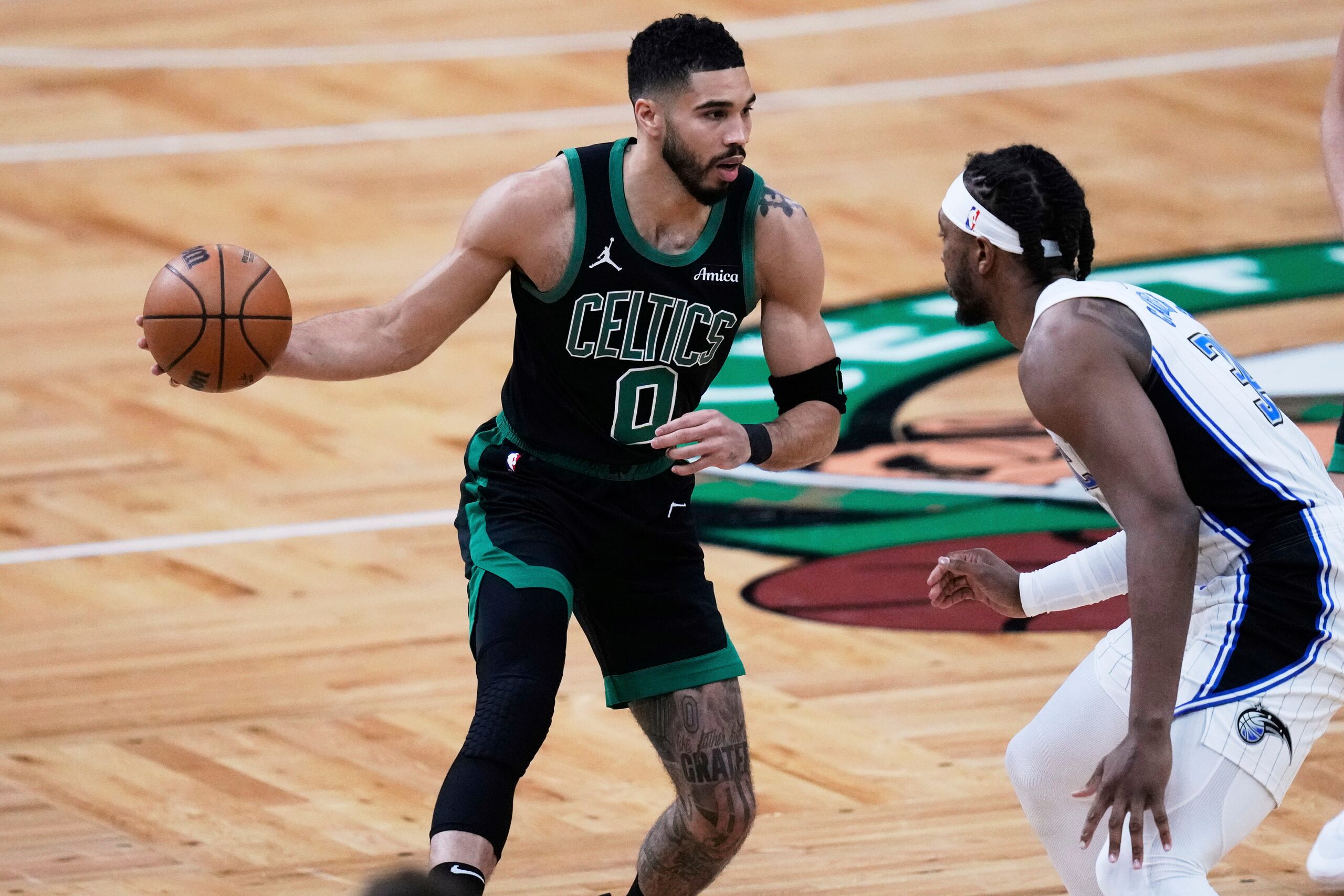 El alero de los Celtics de Boston, Jayson Tatum (0), conduce hacia la canasta contra el pívot del Magic de Orlando Wendell Carter Jr. (34) durante la primera mitad del Juego 5 de una serie de baloncesto de primera ronda de los playoffs de la NBA, el martes 29 de abril de 2025, en Boston.