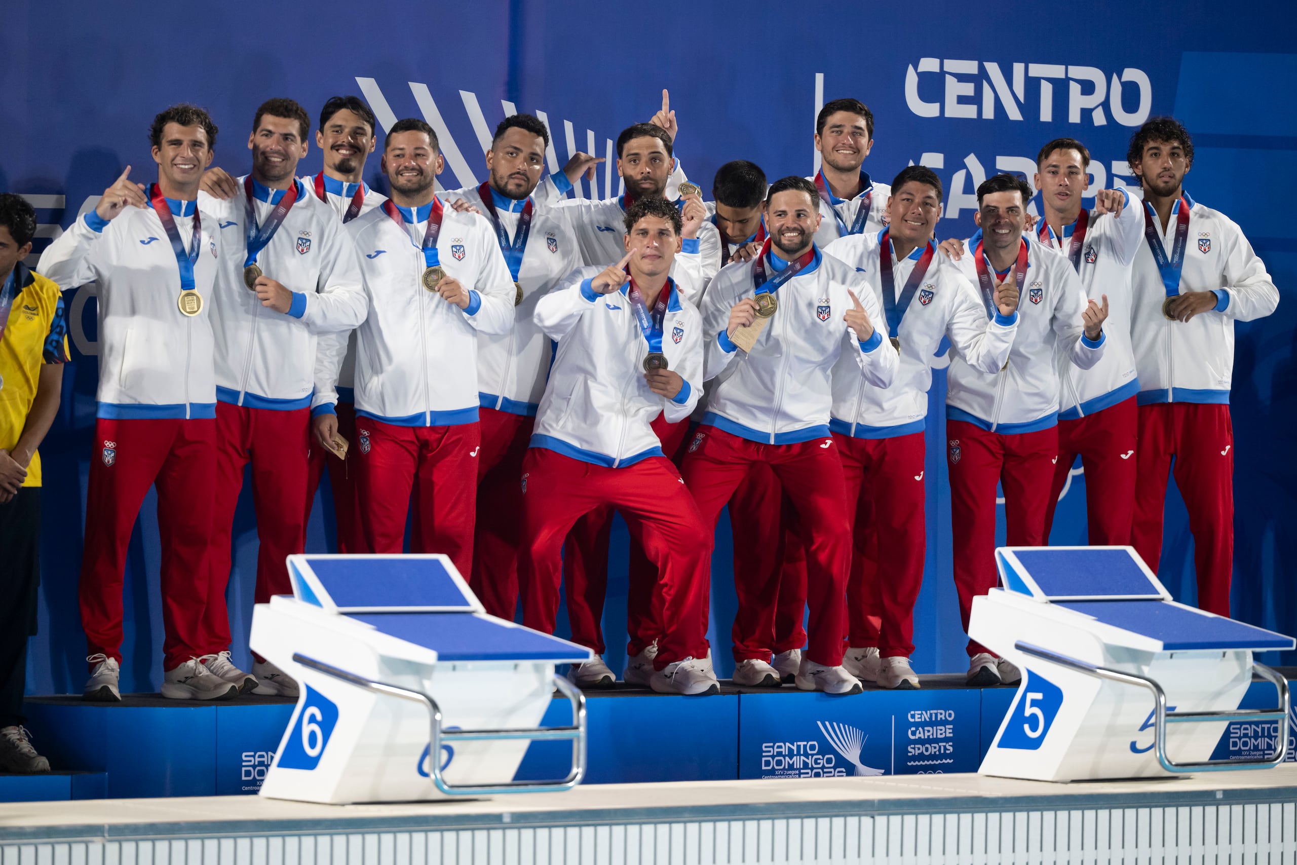 La Selección Nacional de polo acuático masculino posa con la medalla de oro que ganó en los Juegos Centroamericanos y del Caribe Santo Domingo 2026.