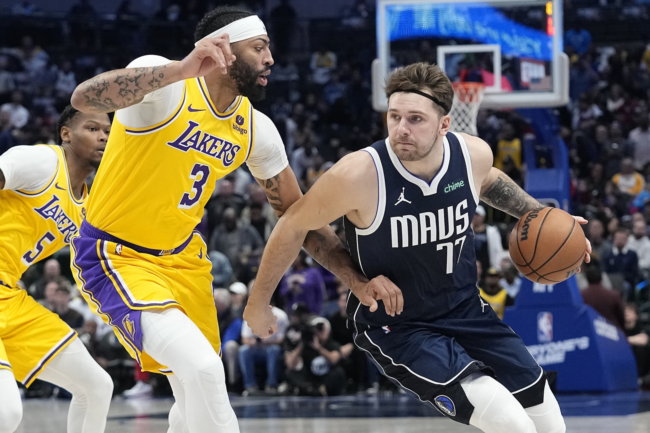 En esta foto de archivo, Luka Doncic (77), de los Mavericks de Dallas, conduce el balón, con la presión de Anthony Davis (3), de los Lakers de Los Ángeles, durante la primera mitad del juego de baloncesto de la NBA, el martes 12 de diciembre de 2023, en Dallas.