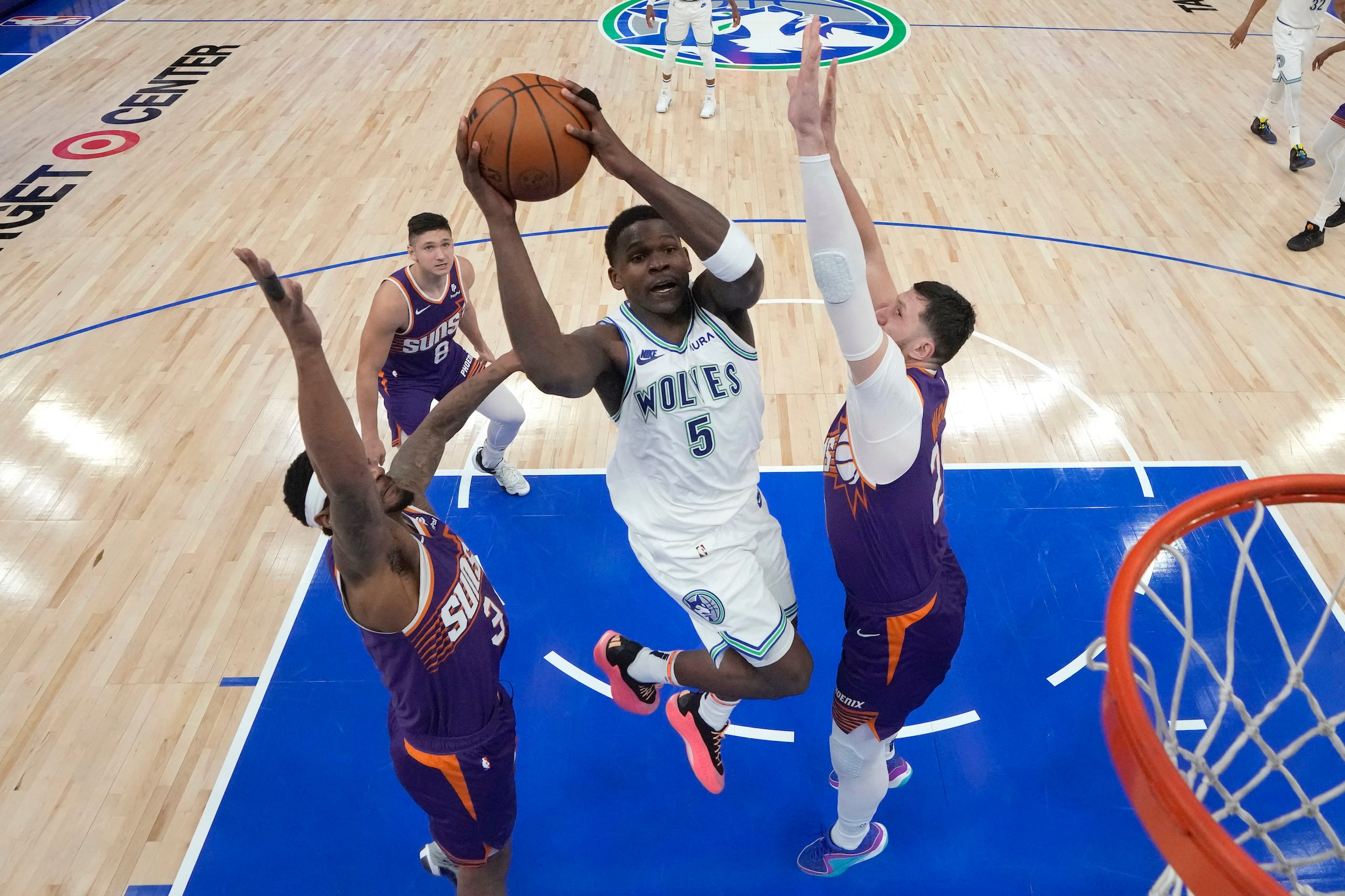 Anthony Edwards, escolta de los Timberwolves de Minnesota, se eleva para disparar frente a Bradley Beal (izquierda) y Jusuf Nurkic, de los Suns de Phoenix.