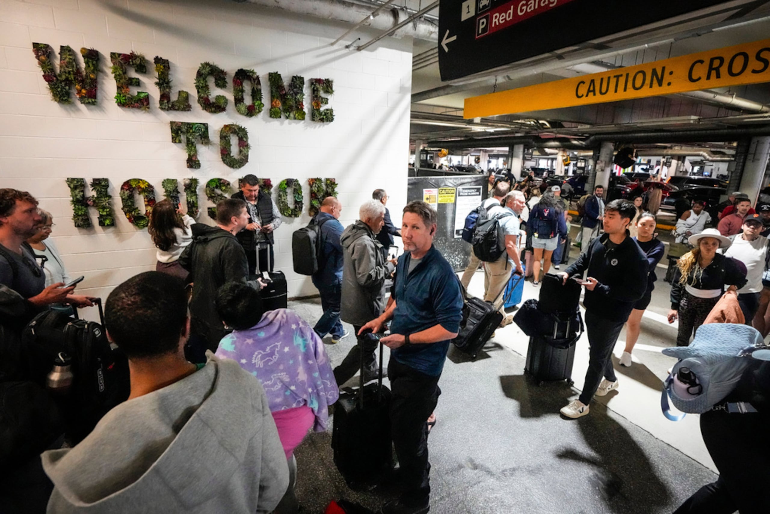 Pasajeros de aerolínea esperan en largas filas afuera de la terminal para pasar por el control de seguridad de TSA en el Aeropuerto William P. Hobby en Houston, el domingo 8 de marzo de 2026.