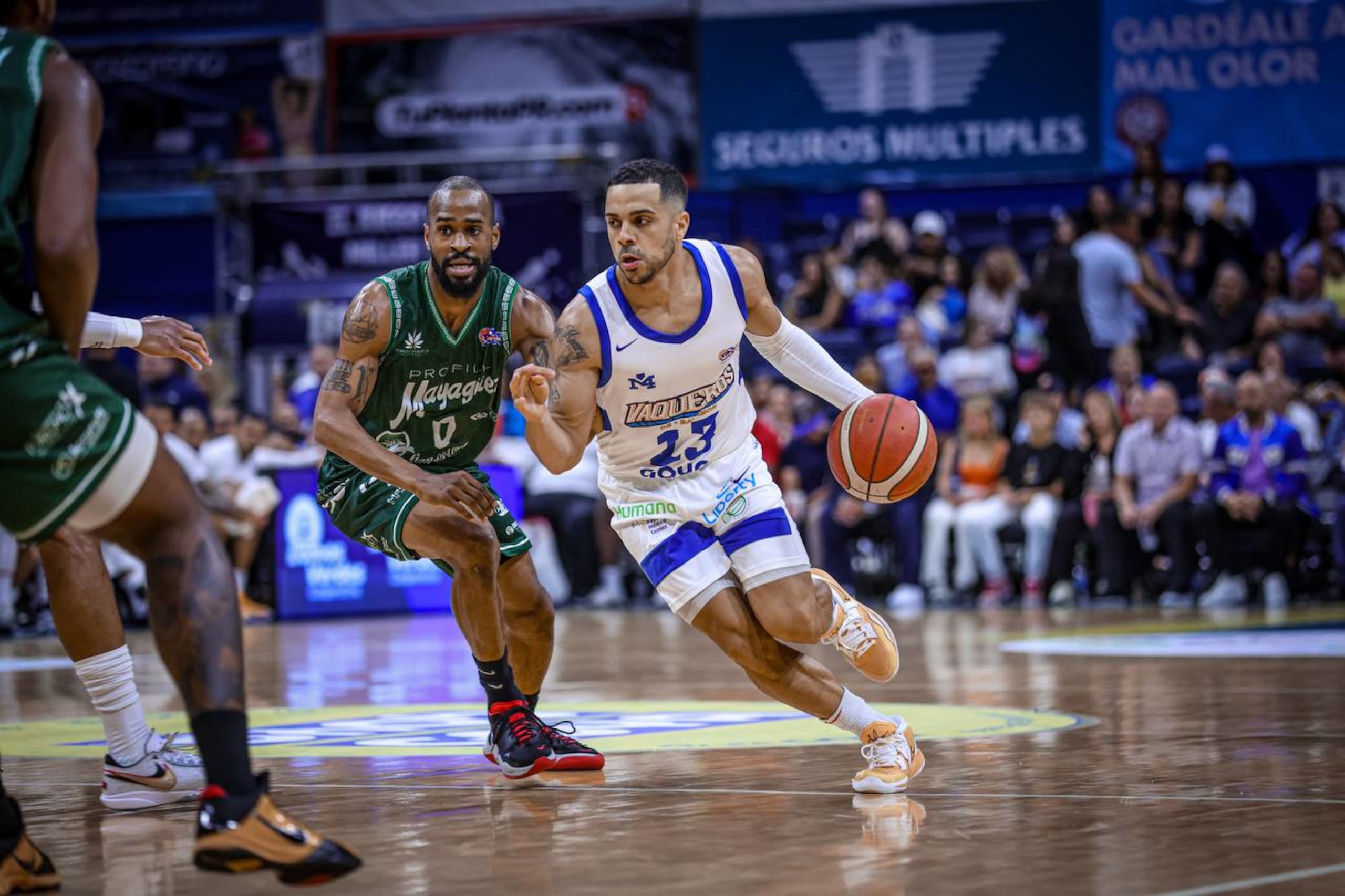El armador de los Vaqueros de Bayamón, Ángel Rodríguez, con el balón, intenta quitarse de encima la defensa de Kyle Viñales, de los Indios de Mayagüez durante el choque del martes en El Rancho Vaquero.