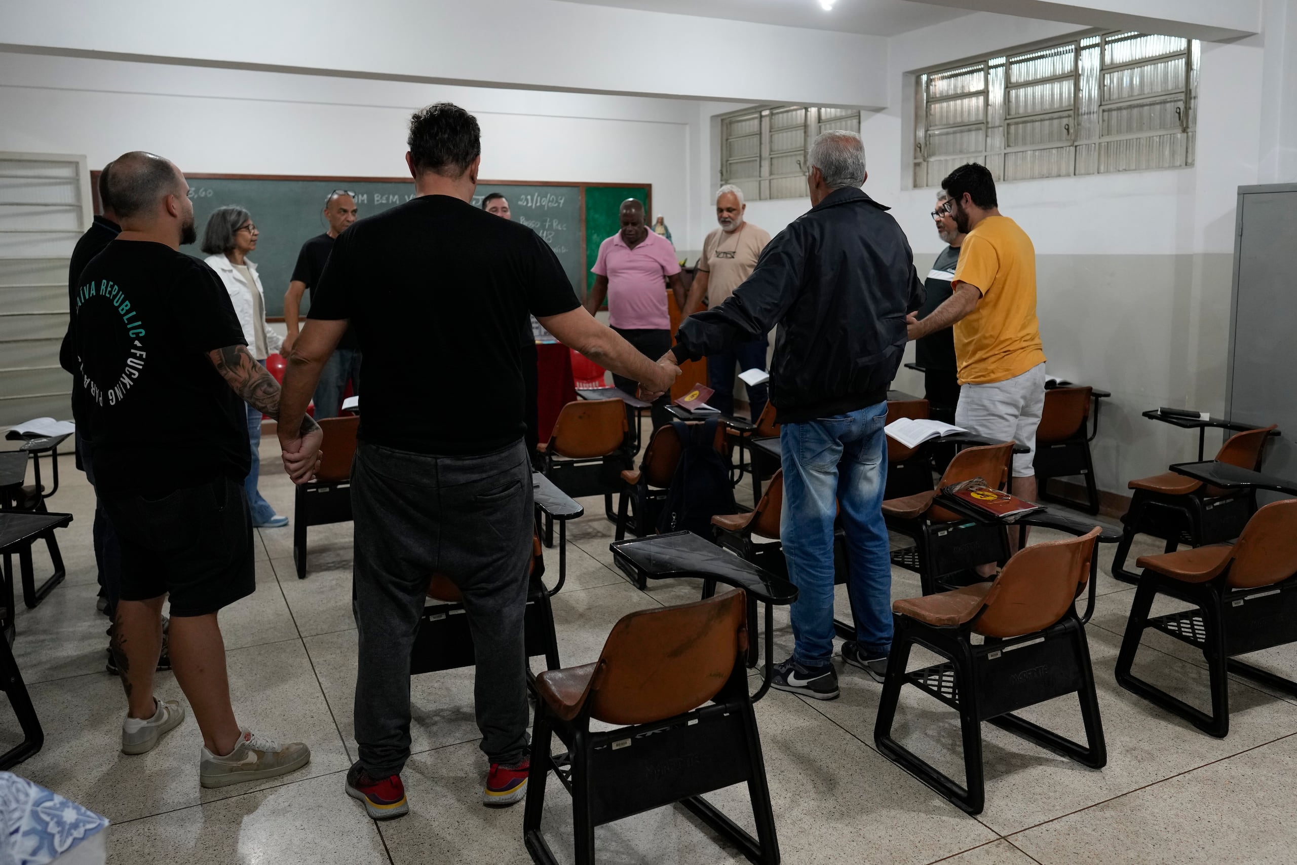 Ludópatas en recuperación oran durante una sesión de Jugadores Anónimos en Sao Paulo, el lunes 21 de octubre de 2024 (AP Foto/Andre Penner)