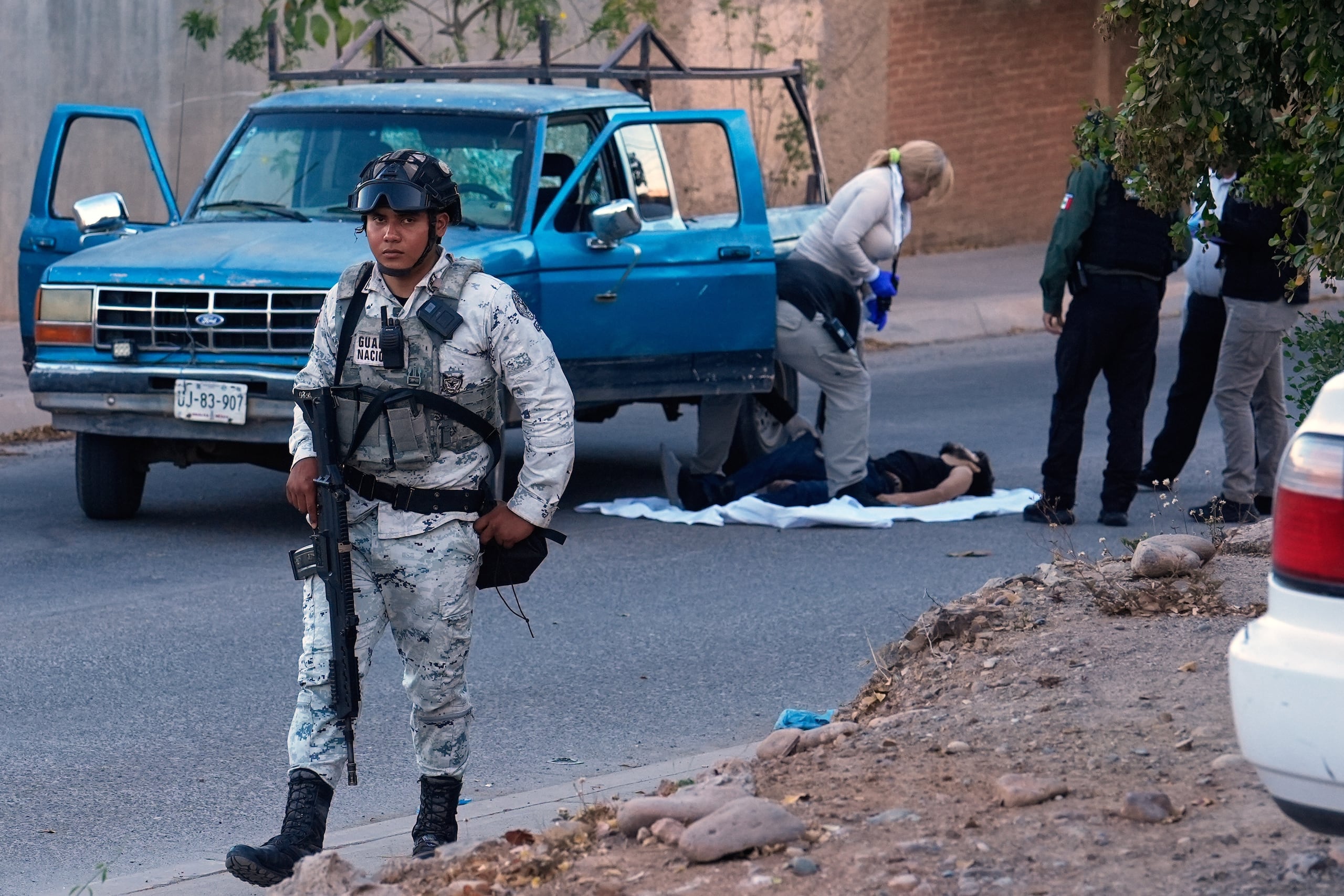 Un miembro de la Guardia Nacional Mexicana vigila mientras expertos forenses inspeccionan el lugar donde se encontró el cuerpo de una víctima de un ataque armado mortal en Culiacán, estado de Sinaloa, México. En el país existe 50.4 asesinatos por día, y esa es la cifra más baja en una década.