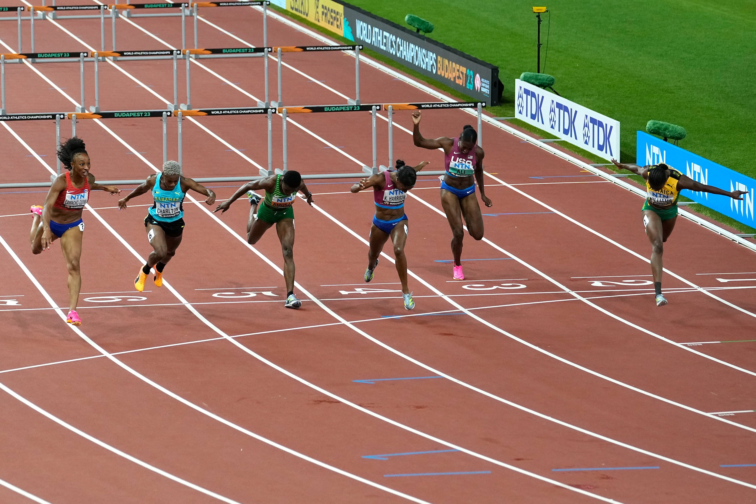 Danielle Williams, de Jamaica, por el carril número 1, completa su corrida mientras el resto de las corredoras, incluida Jasmine Camacho Quinn, a la izquierda, hacían su esfuerzo final por ganar la prueba. Williams se llevó el oro con 12.43 segundos y Camacho Quinn la plata con 12.44.