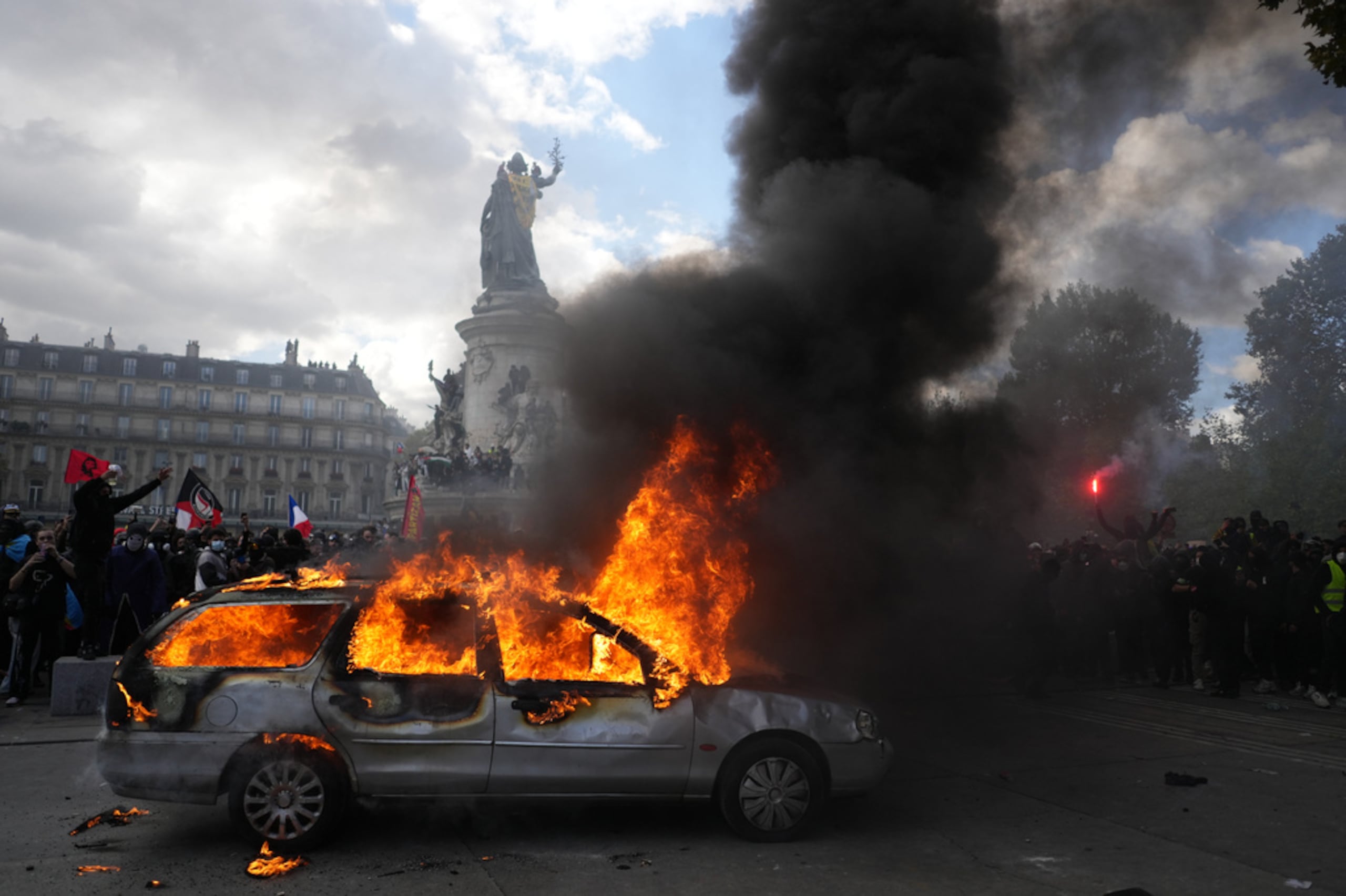 Un auto incendiado en la plaza de la República durante una protesta contra el aumento del costo de vida, a la que se sumaron reclamos de estudiantes, en París, este sábado.
