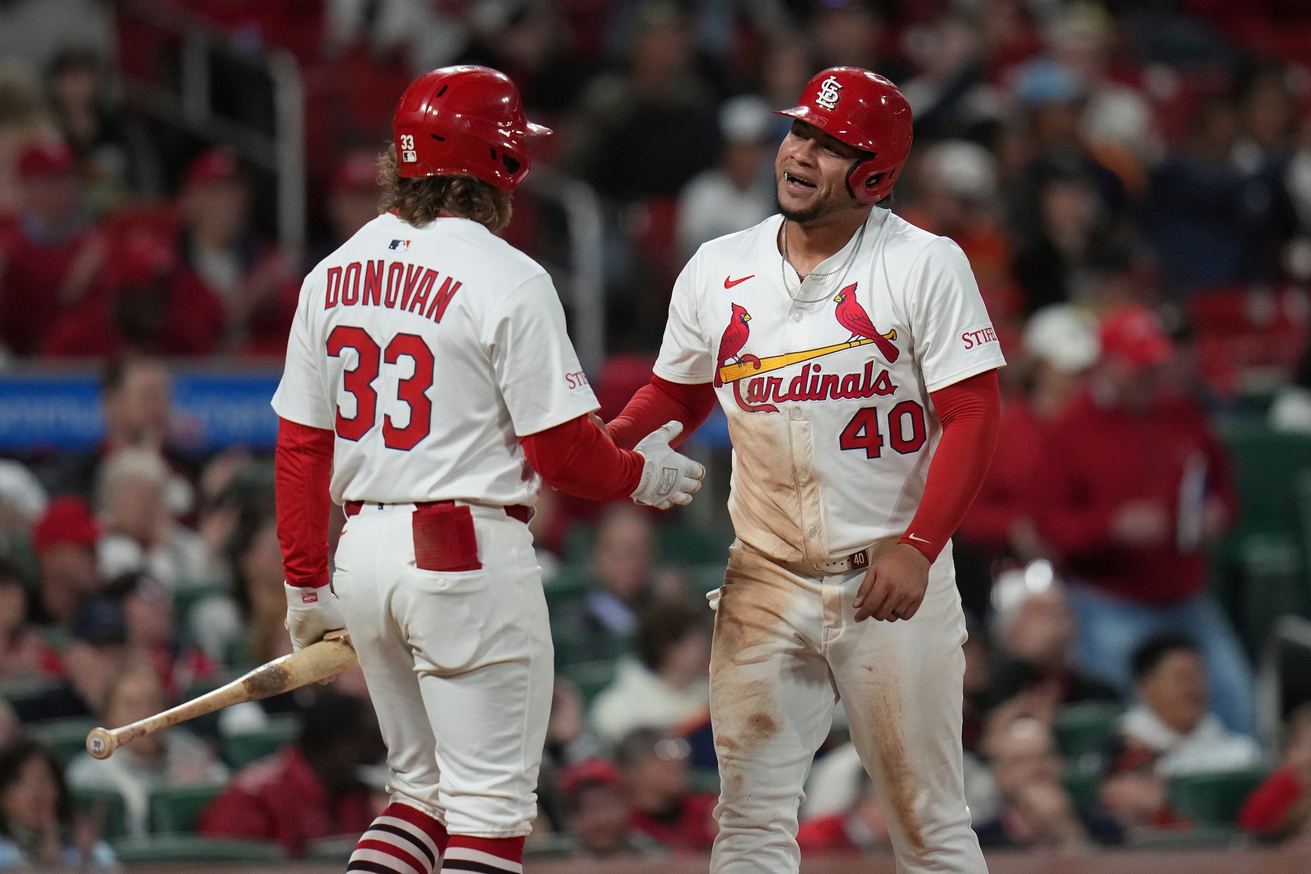 Willson Contreras (40), de los Cardenales de San Luis, es felicitado por su compañero de equipo Brendan Donovan después de anotar durante la quinta entrada del juego de béisbol contra los Astros de Houston el lunes 14 de abril de 2025, en San Luis. (AP Foto/Jeff Roberson)