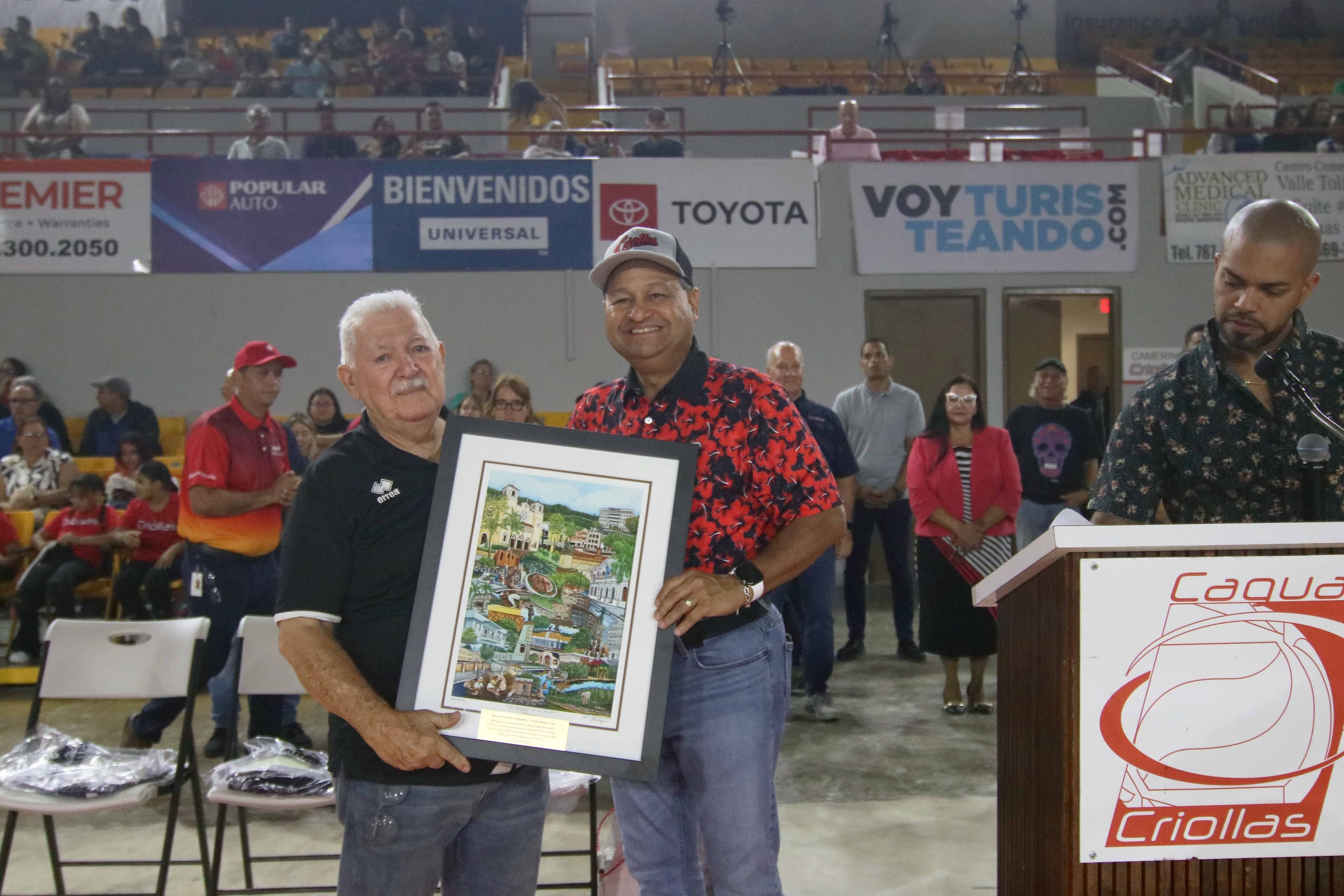 Ángel Dieppa Díaz, a la izquierda, recibe de parte del alcalde de Caguas, William Miranda Torres, la dedicatoria de la temporada 2024 de las Criolllas.