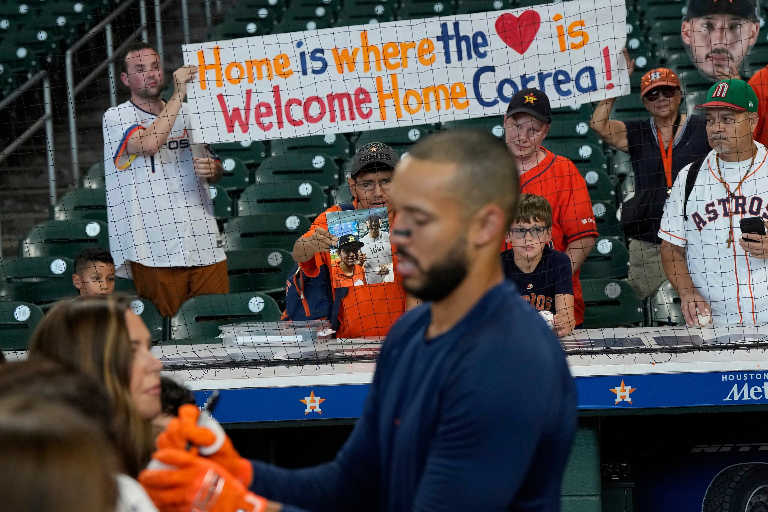 Un grupo de fanáticos le muestra a Carlos Correa una pancarta que dice que la casa es donde está  el corazón.