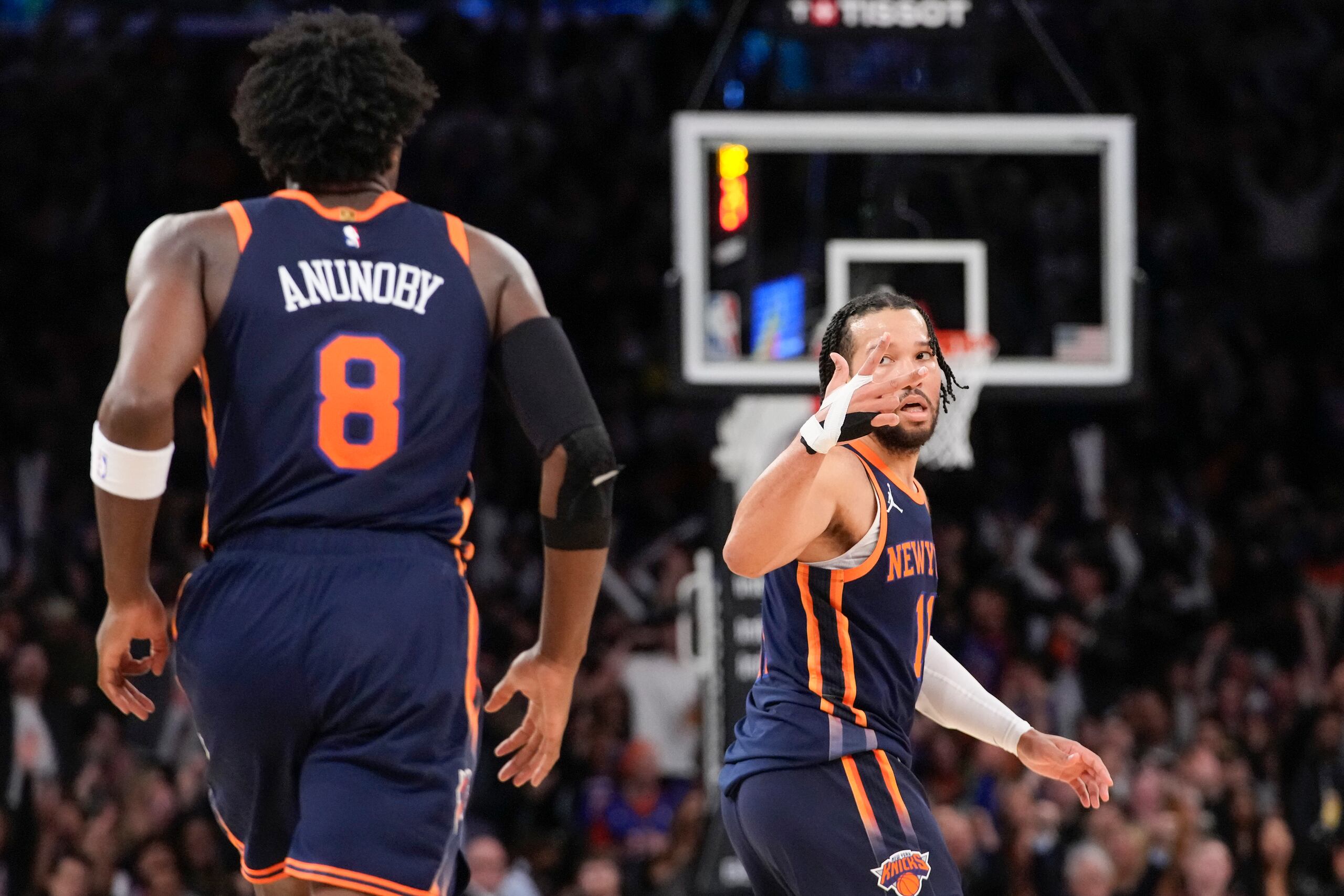 El armador de los New York Knicks, Jalen Brunson, hace un gesto hacia el alero O.G. Anunoby después de que Anunoby encestara un triple.