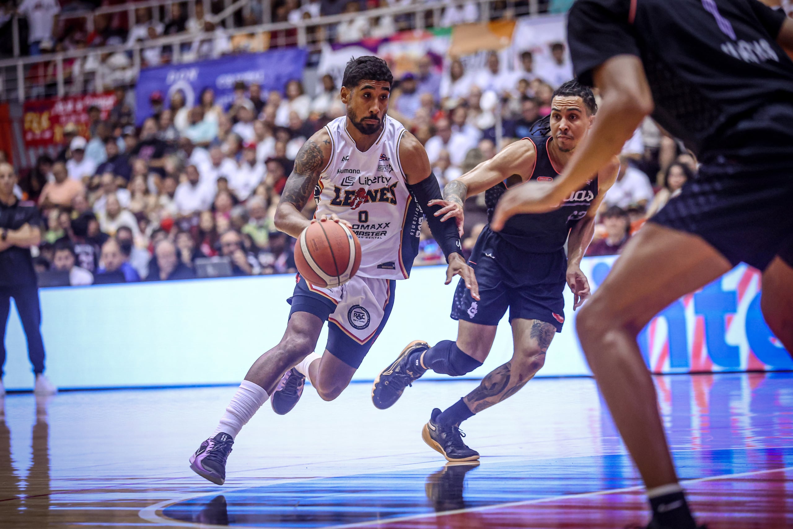 Jezreel De Jesús, de los Leones de Ponce, maneja el balón ante Travis Trice, de los Criollos de Caguas, durante la semifinal 2024 del BSN.