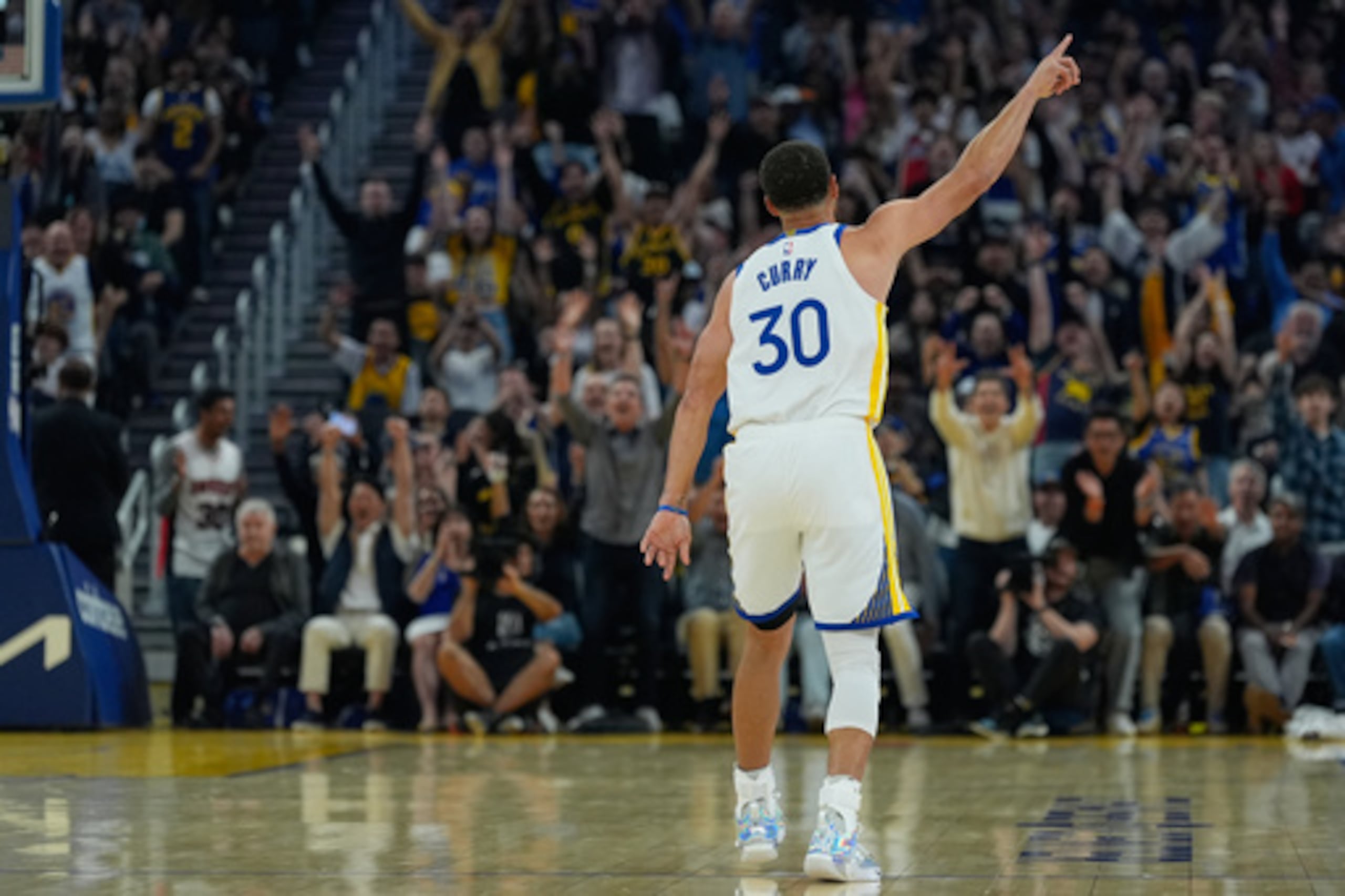 El escolta Stephen Curry celebra después de encestar una canasta de tres puntos durante la primera mitad de un partido de baloncesto de la NBA contra los Rockets.