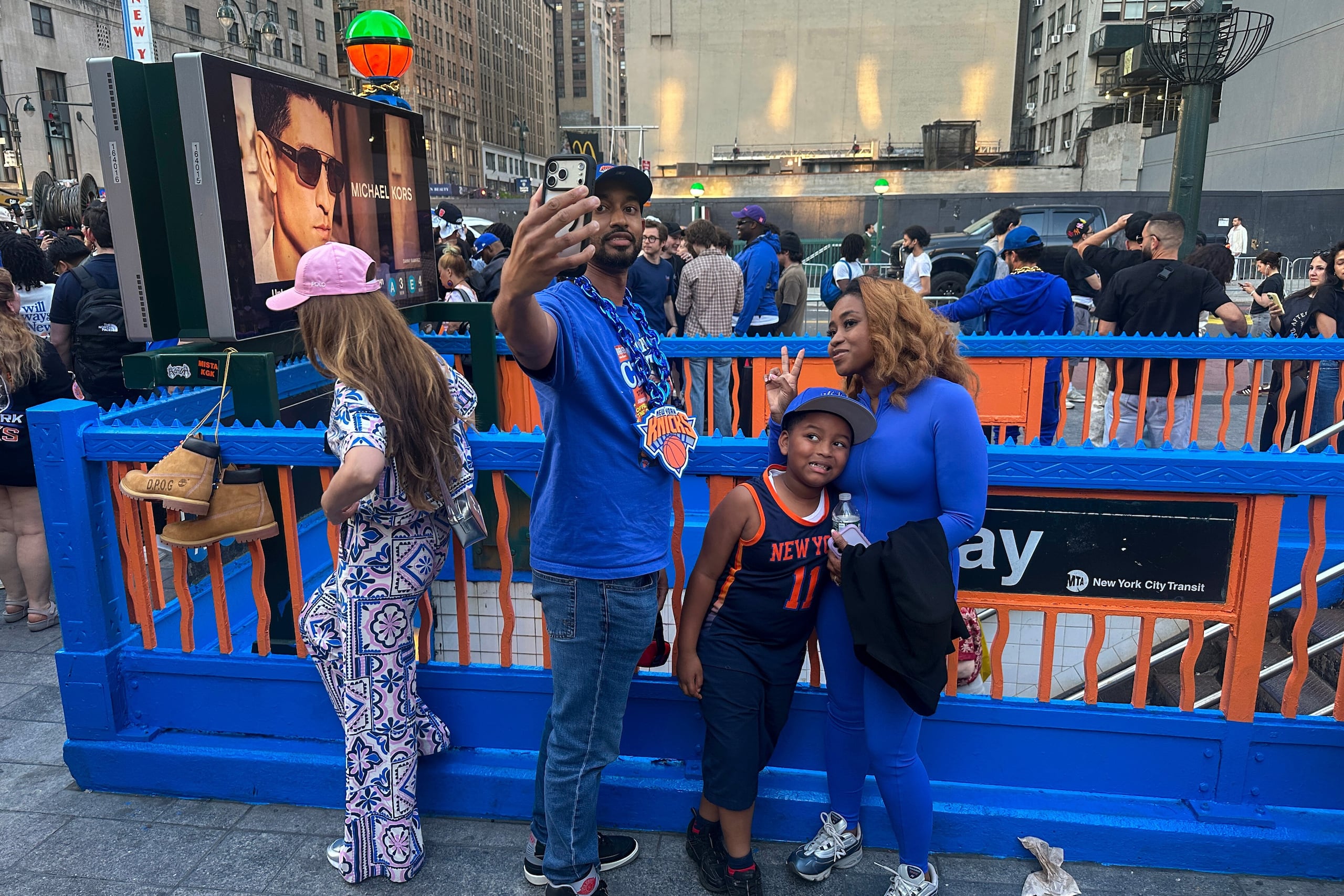 Seguidores de los Knicks de Nueva York posan en una entrada al tren subterráneo, el miércoles 3 de junio de 2026.