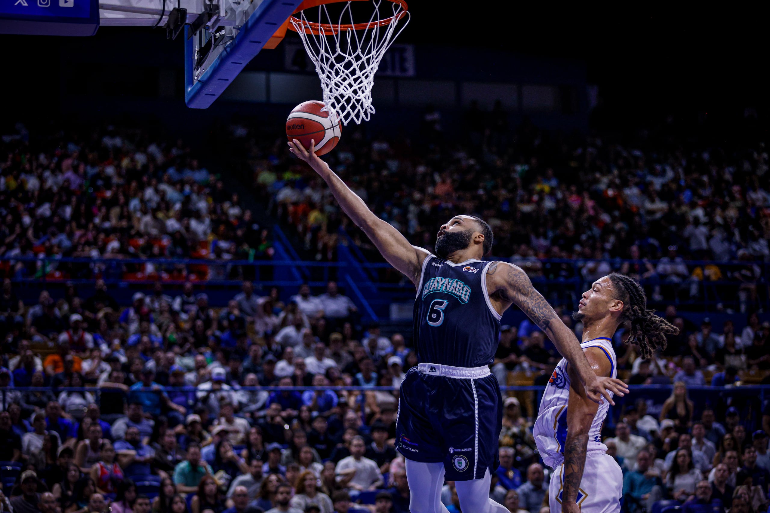 Jaysean Paige, de los Mets de Guaynabo, ataca el canasto ante Isaiah Palermo, de los Vaqueros de Bayamón.
