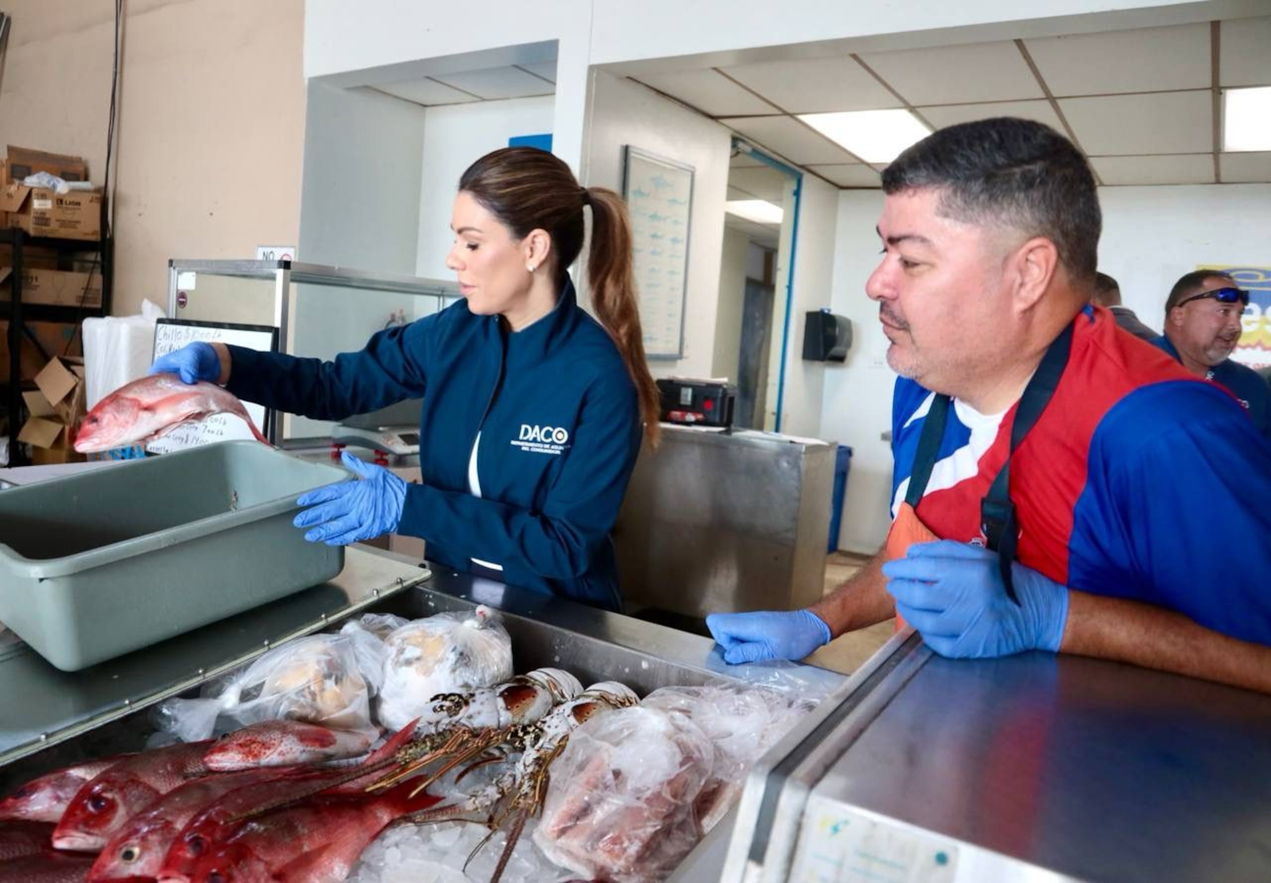 La secretaria de DACO, Valerie Rodríguez Erazo, junto a personal de su agencia, inspecciona algunos establecimientos de venta de pescados y mariscos.