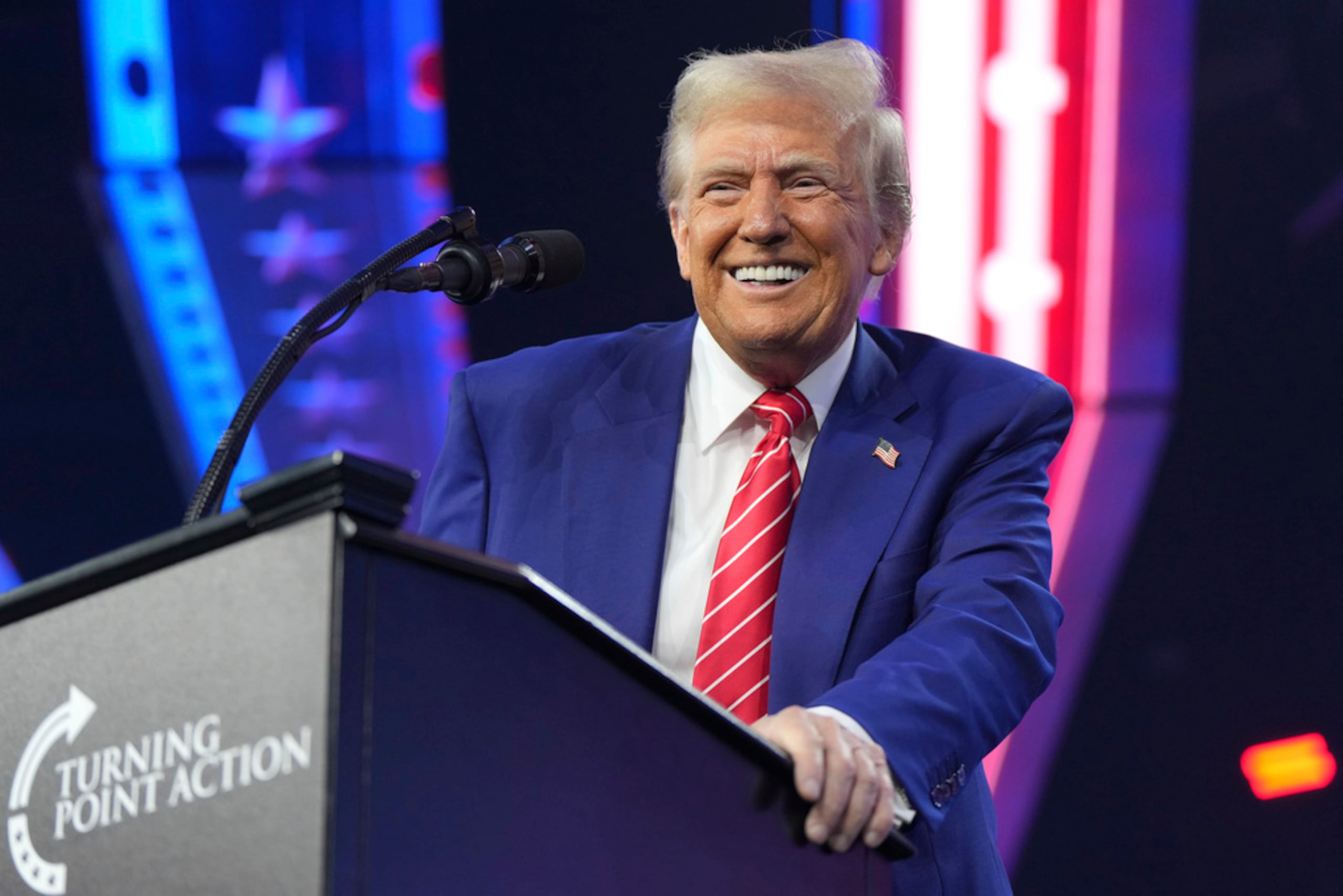 El presidente electo Donald Trump sonríe al hablar en el evento AmericaFest, el domingo 22 de diciembre de 2024, en Phoenix.