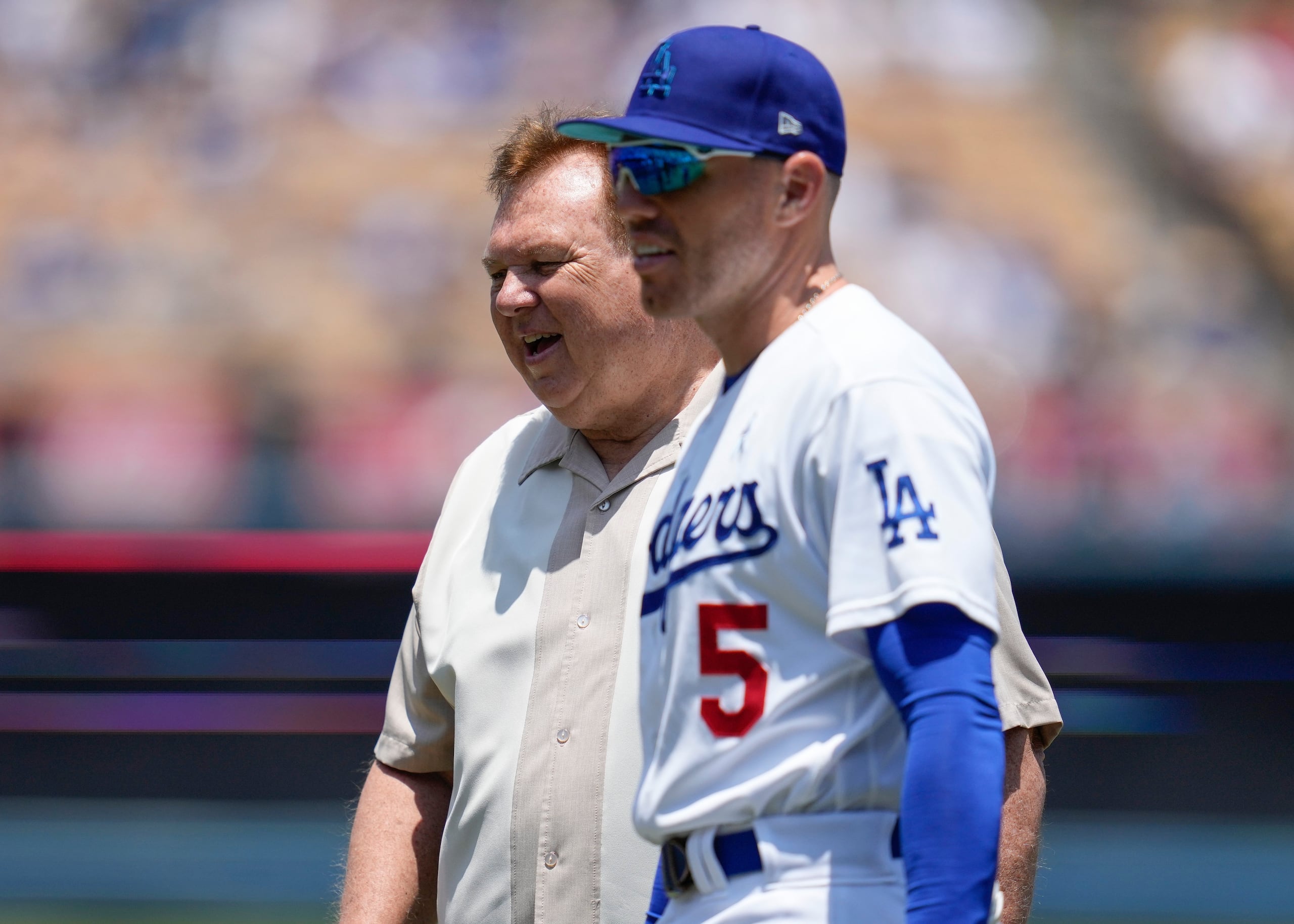 Freddie Freeman (5), primera base de los Dodgers de Los Ángeles, camina en el campo al lado de su padre, Fred Freeman, previo a un partido de béisbol de Grandes Ligas contra los Gigantes de San Francisco, el domingo 8 de junio de 2023, en Los Ángeles.
