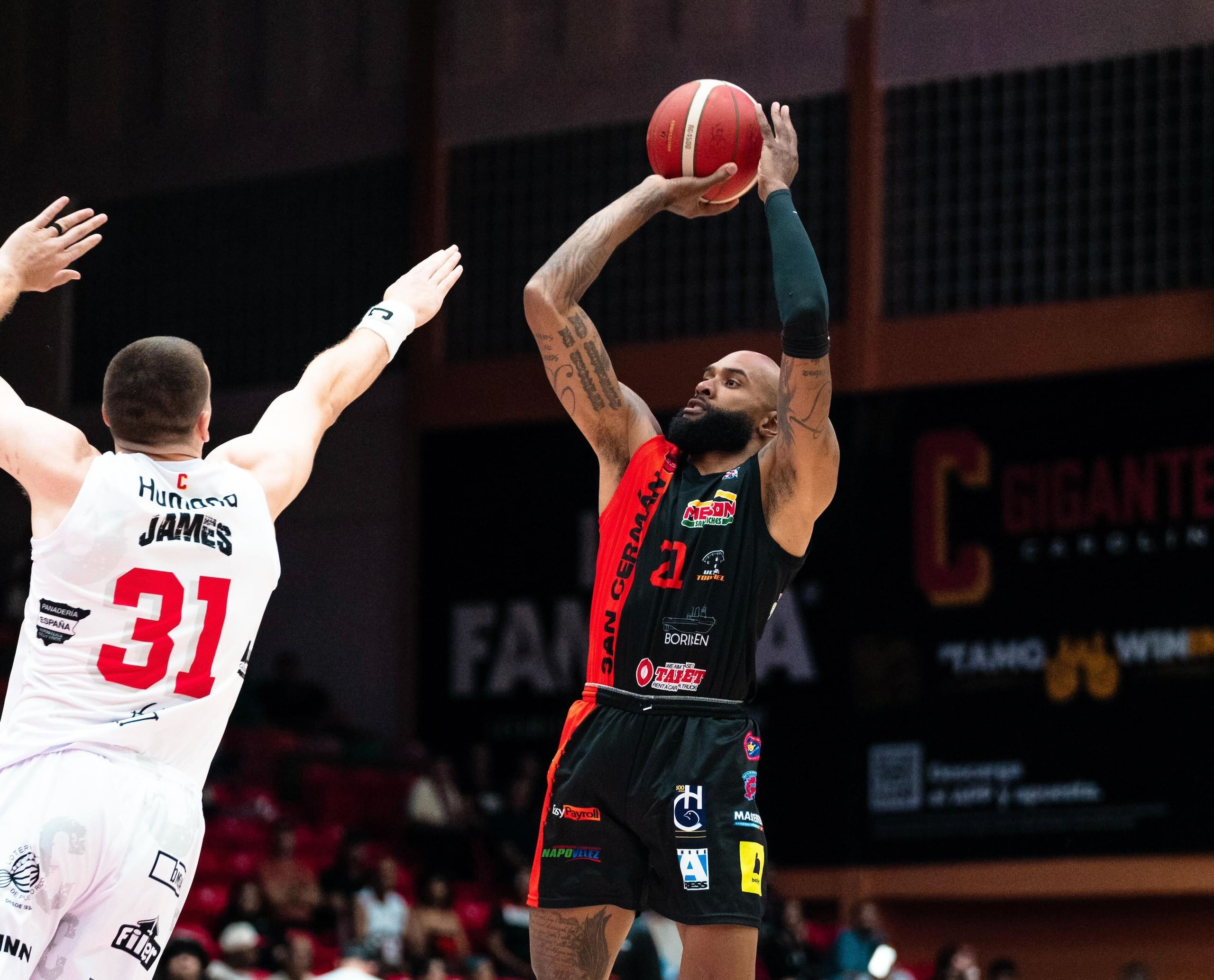 Tony Bishop, de los Atléticos de San Germán, lanza al canasto ante la defensa de Scottie James, de los Gigantes de Carolina.