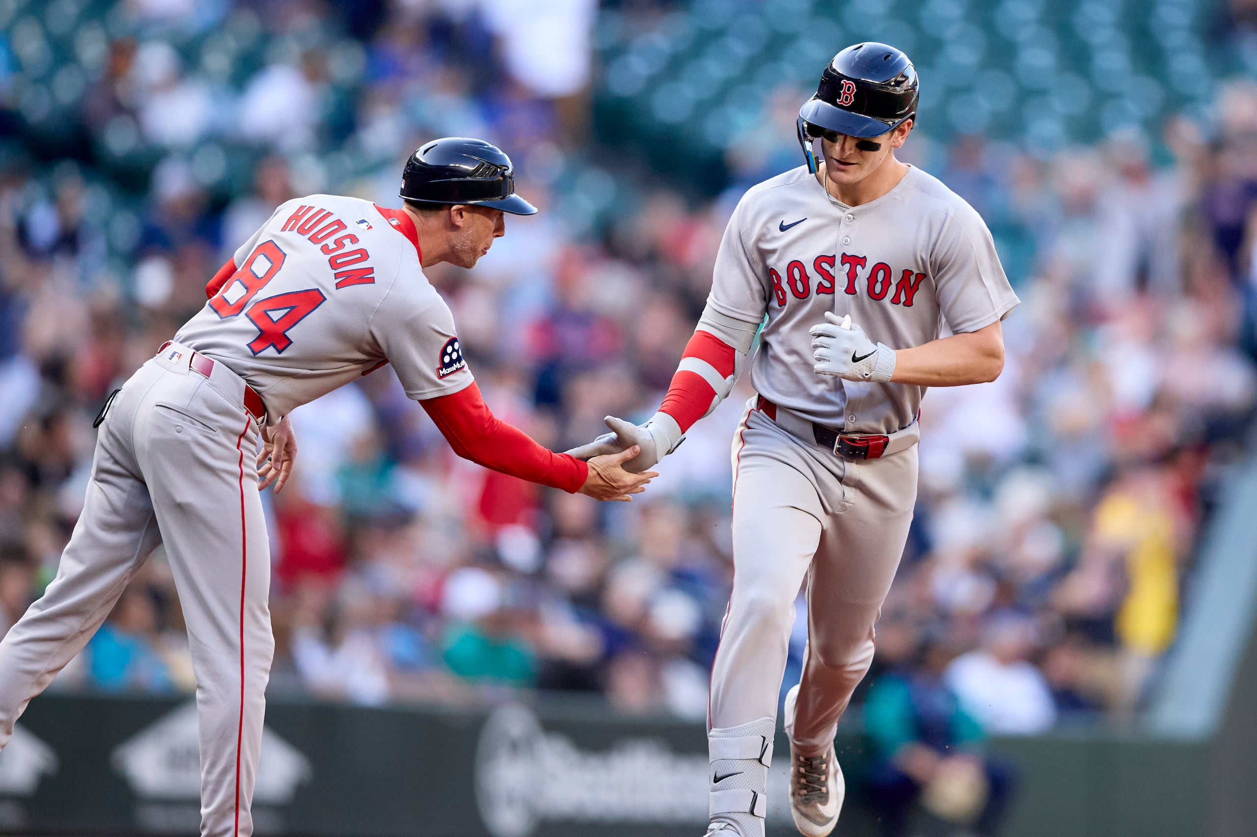 Roman Anthony, derecha, de los Red Sox de Boston, es felicitado por el coach de tercera base, Kyle Hudson, después de batear un cuadrangular solitario frente al abridor de los Marineros de Seattle, Logan Gilbert, durante la primera entrada del juego de béisbol de Grandes Ligas.