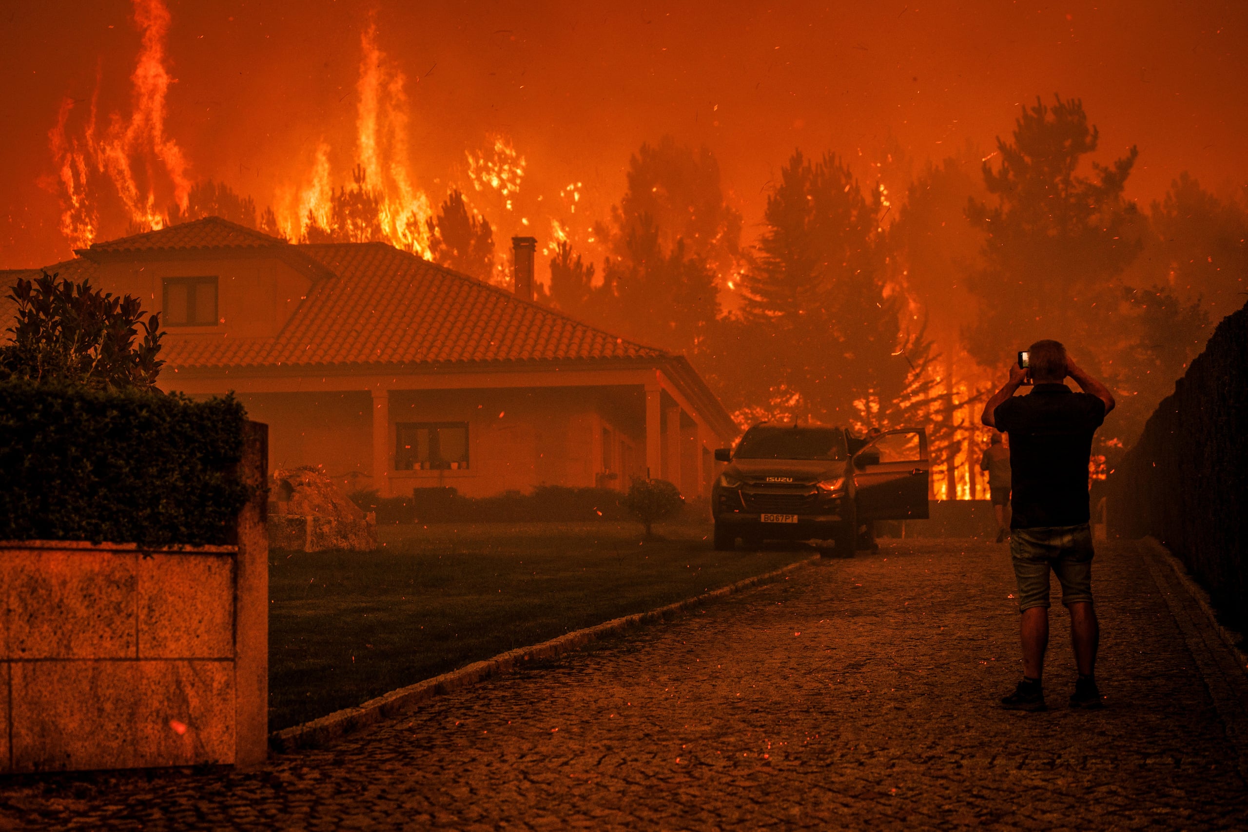 Un hombre observa cómo un incendio forestal se desata cerca de una casa en Granja do Paiva, municipio de Sernancelhe, distrito de Viseu, Portugal.