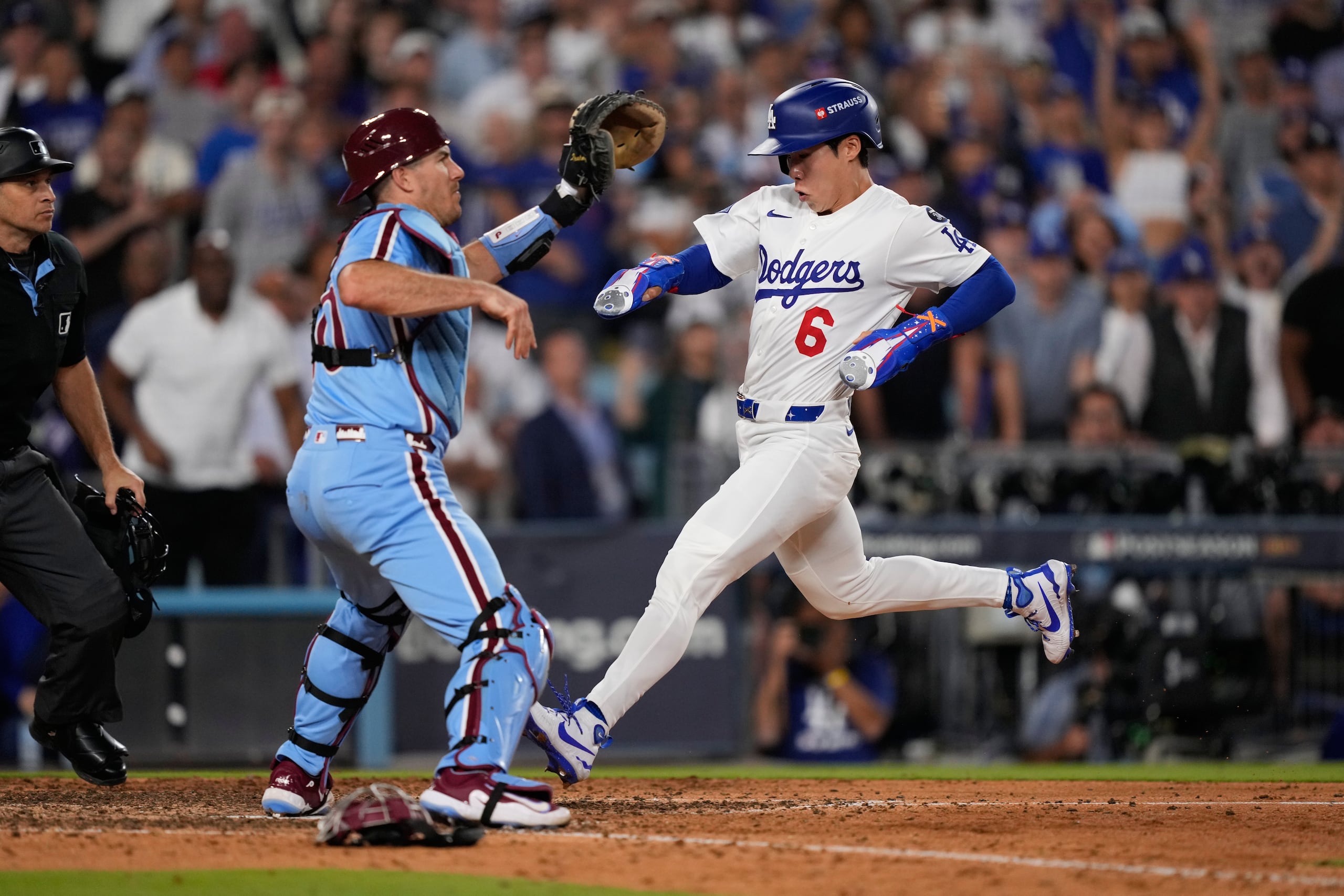 Hyeseong Kim, de los Dodgers, anota la carrera de la victoria al pasarle al receptor de los Phillies J.T. Realmuto, quien no pudo atrapar un tiro errado del relevista Orion Kerkering en la undécima entrada.