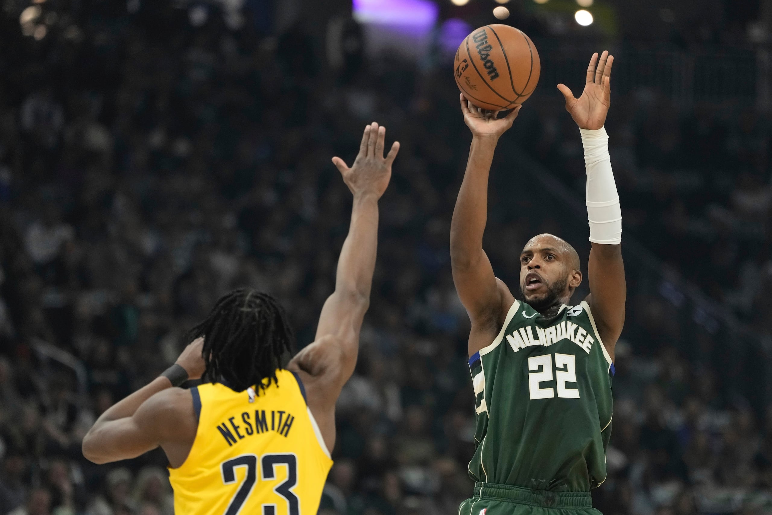 Khris Middleton de los Bucks de Milwaukee lanza el balón sobre Aaron Nesmith de los Pacers de Indiana en el juego 5 de la primera ronda de la postemporada el martes 30 de abril del 2024. (AP Foto/Morry Gash)