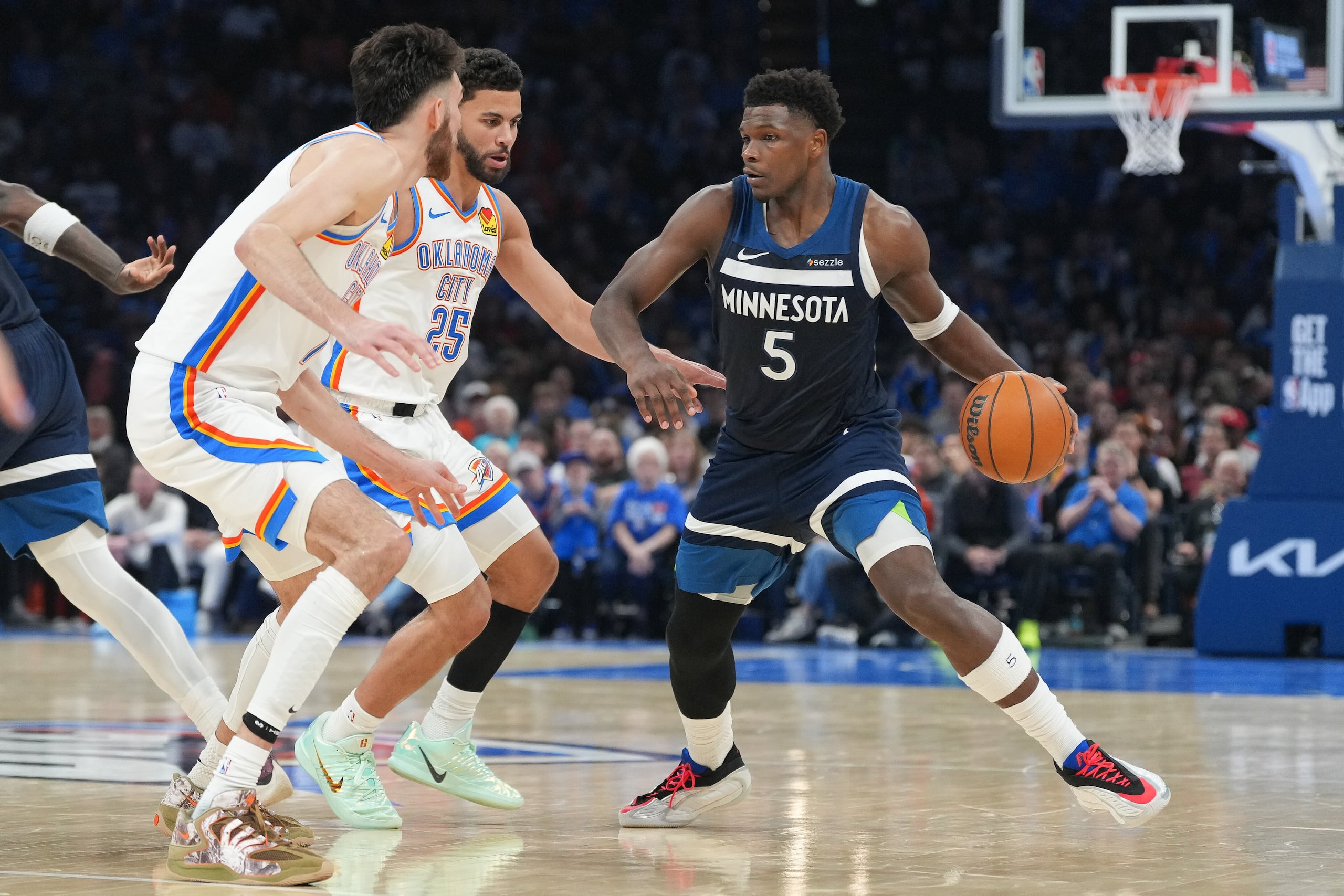 El base de los Timberwolves de Minnesota, Anthony Edwards (derecha), busca un espacio ante el pívot Chet Holmgren (izquierda) y el base Ajay Mitchell (centro), del Thunder de Oklahoma City, durante la segunda mitad de un juego de baloncesto de la NBA, el domingo 15 de marzo de 2026, en Oklahoma City. (Foto AP/Kyle Phillips)