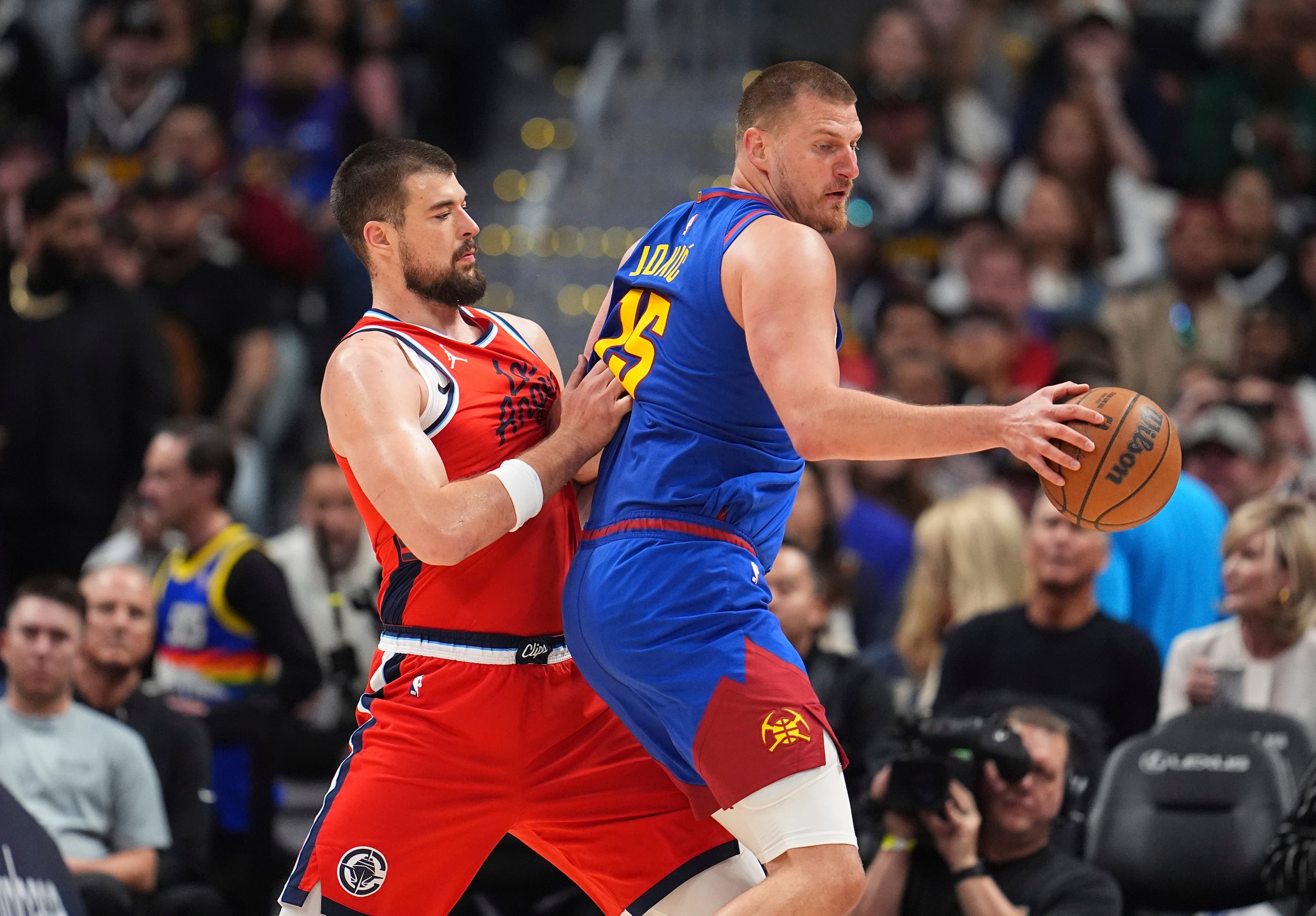 Nikola Jokic, de los Nuggets de Denver, busca pasar el balón ante la defensa de Ivica Zuba, de los Clippers de Los Ángeles.