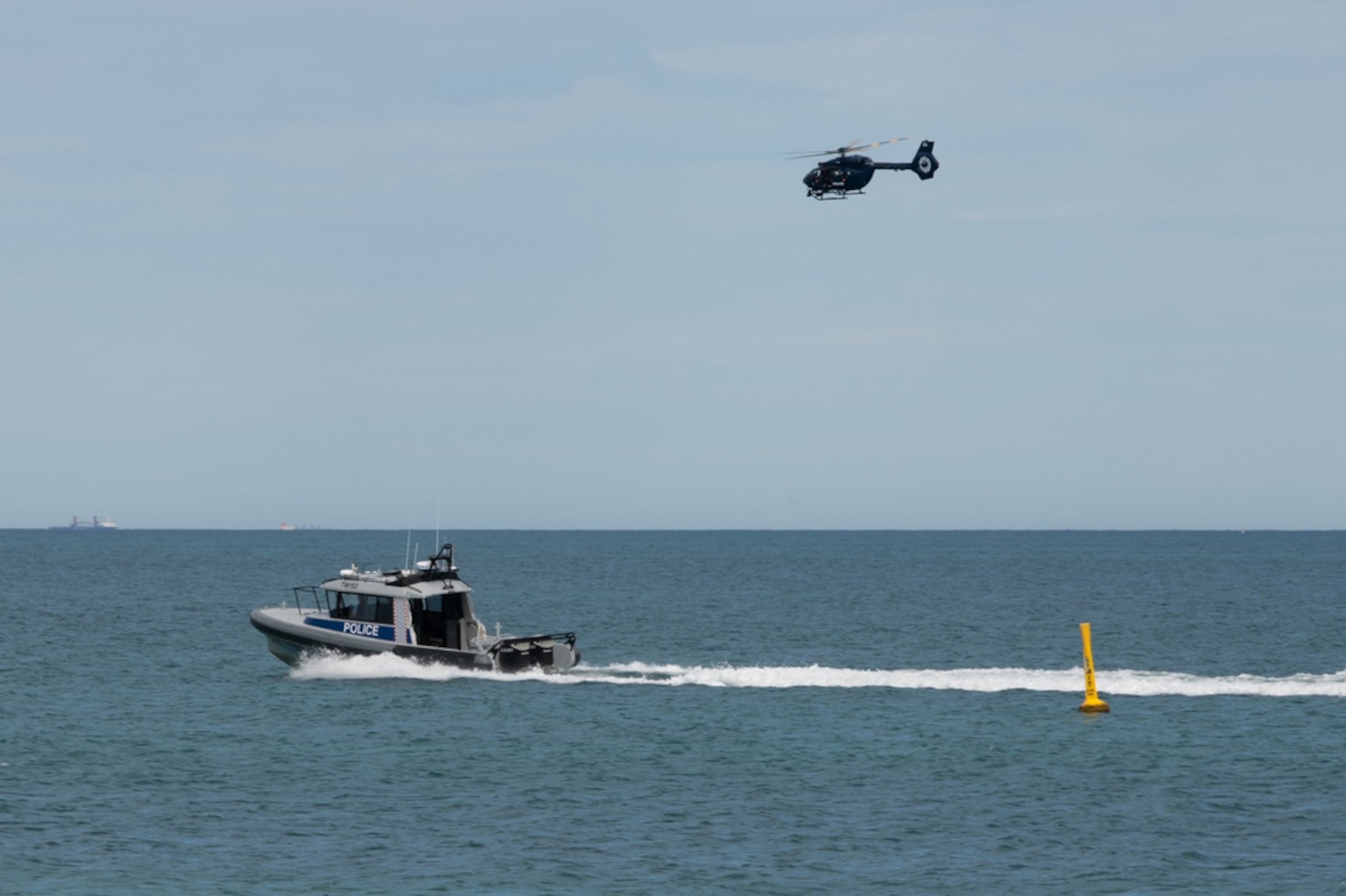Un barco y un helicóptero de la policía patrullan una zona de la playa de Sorrento, en Perth, Australia, el 18 de septiembre de 2026, tras un ataque mortal de tiburón.